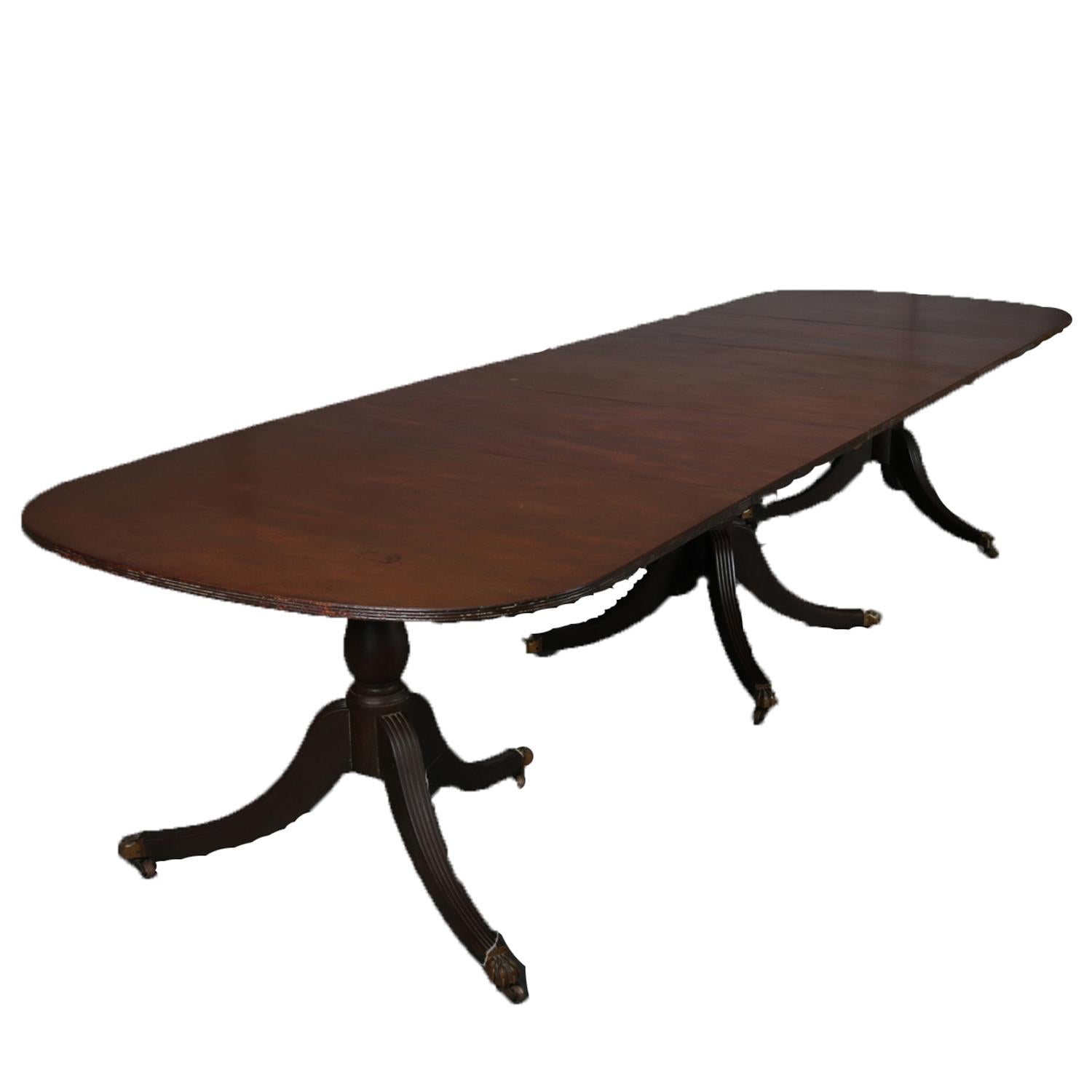 An antique Federal banquet table features mahogany construction, is raised on three pedestals each having reeded convex tripod legs terminating in bronze caps with casters, and has two leaves, circa 1890.


Measures: 30