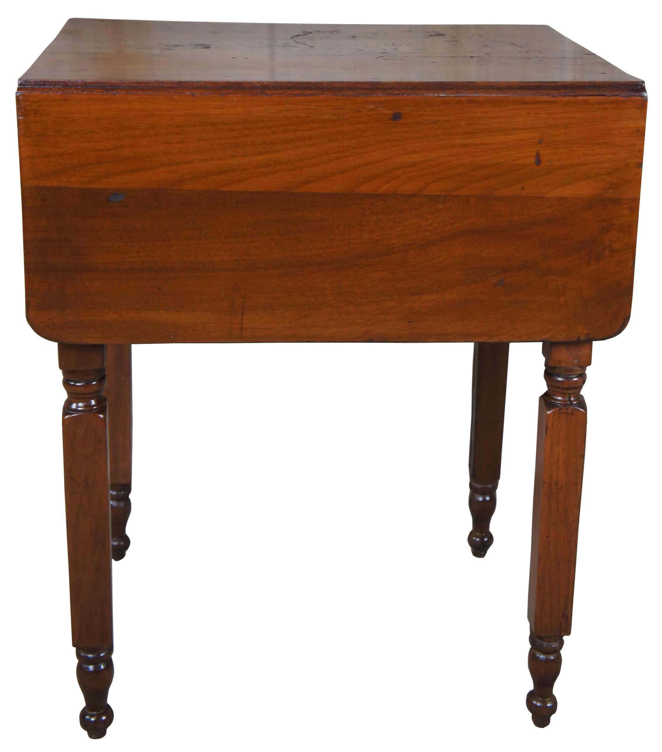 Mid-19th century Federal / early American style drop leaf side table. Features two hand dovetailed drawers with a crotch walnut veneer supported by four square legs leading to turned feet.

Opens to 38.5