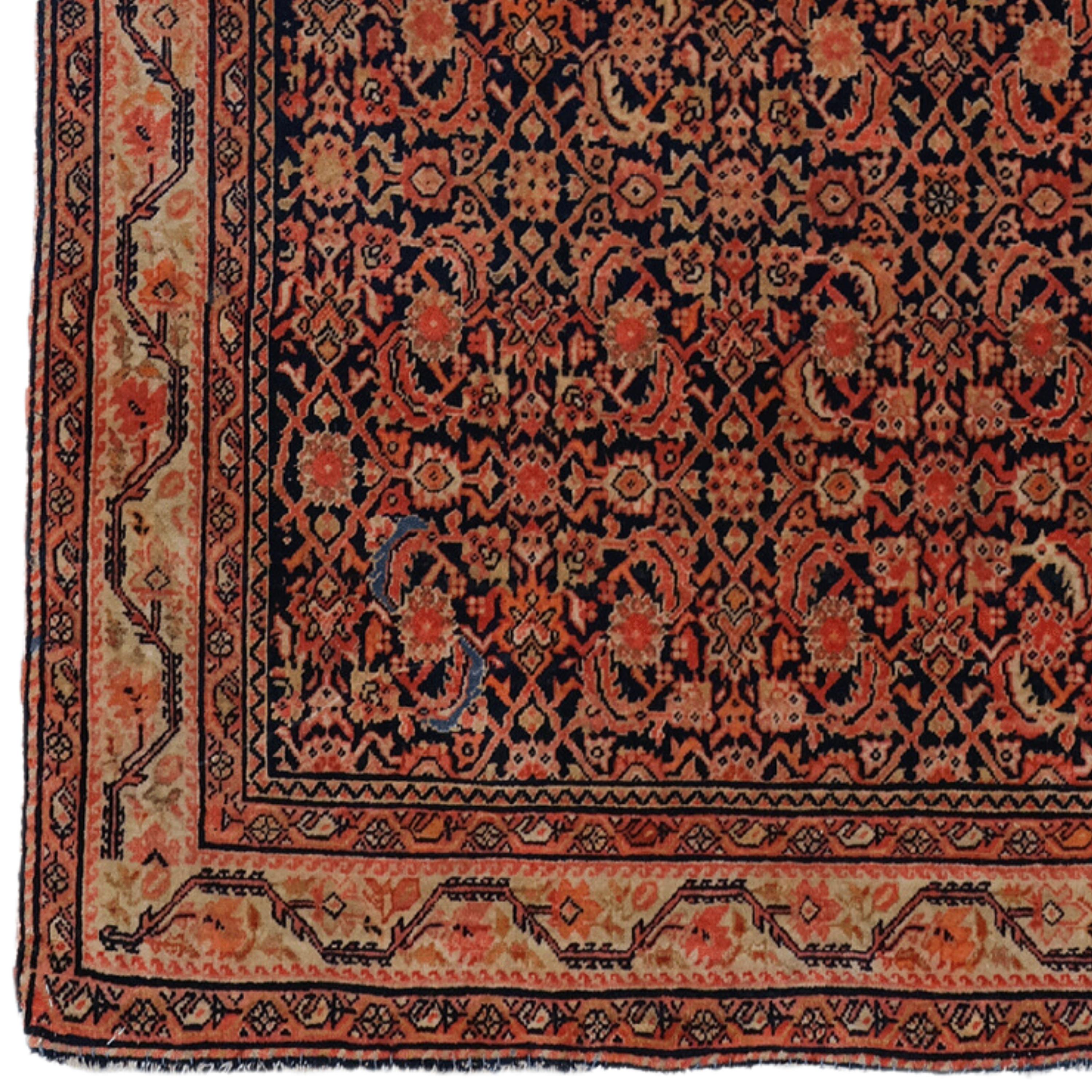 This elegant 19th-century Feraghan carpet is an example of the most exquisite craftsmanship of its period. It adds nobility to any space with its rich history and sophisticated design. Vibrant red and golden motifs embroidered on a dark blue