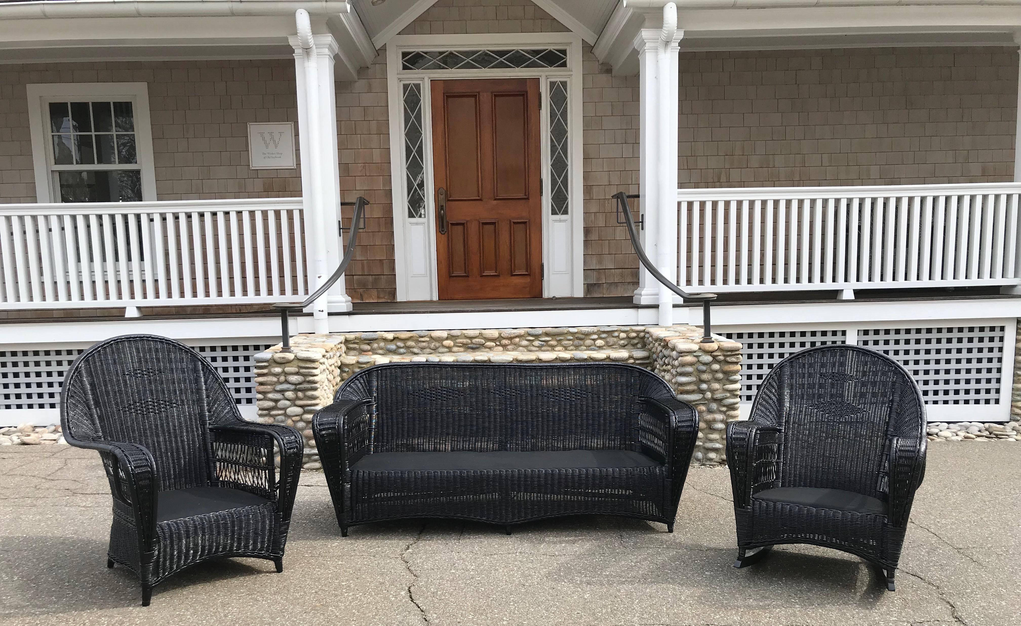 Antique Ficks Reed wicker set in fresh black paint. Sofa, chair and rocker in closely woven pattern with open lattice work under the arms. Pieces are fully skirted for tailored look on all sides.
Sofa measures 71