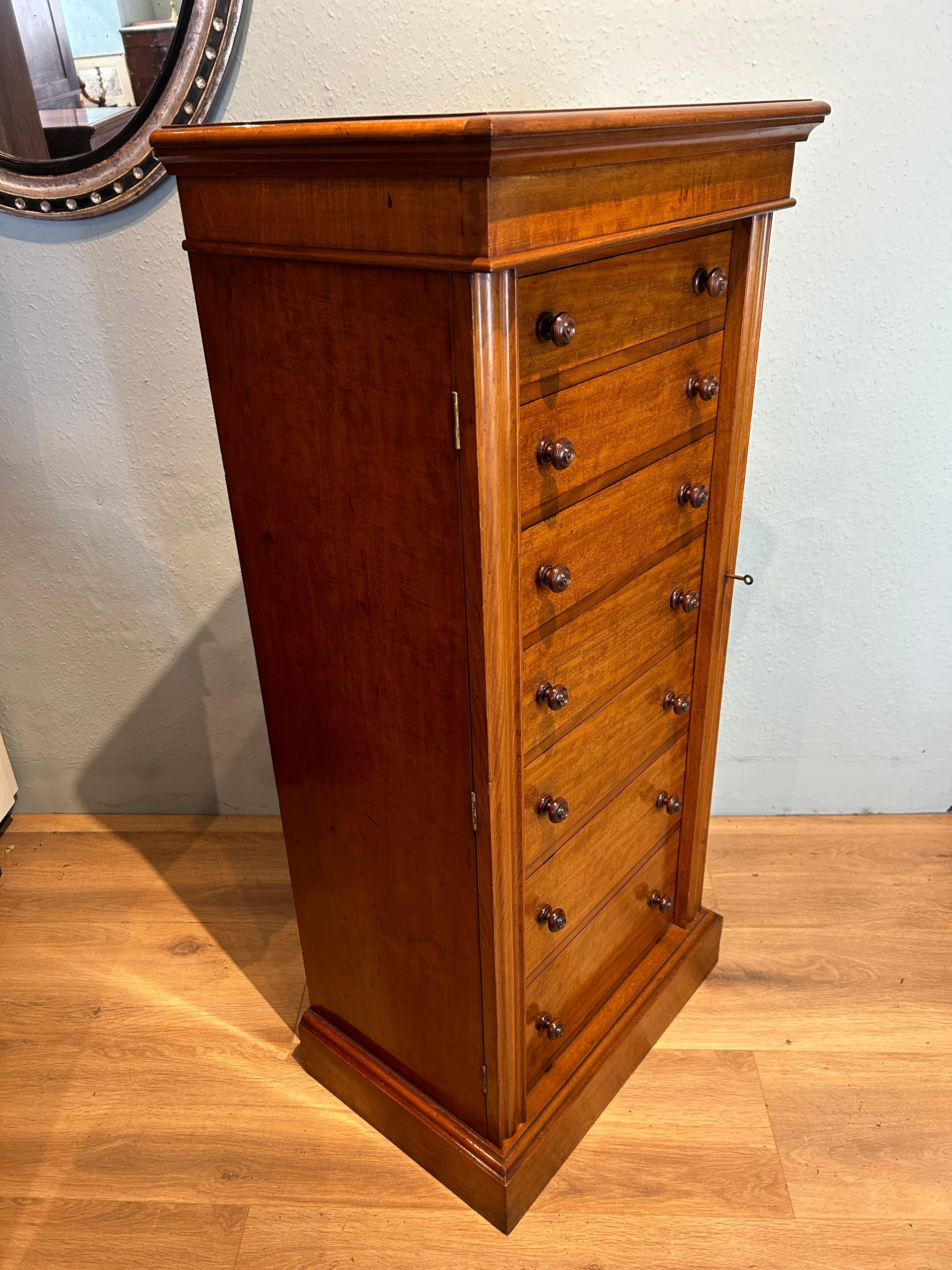 Extremely good quality fiddleback mahogany veneer Wellington chest of drawers, made in England, circa 1850.  The attractive double moulded top, rests on seven mahogany lined drawers with original wooden screw threaded turned knob handles. The