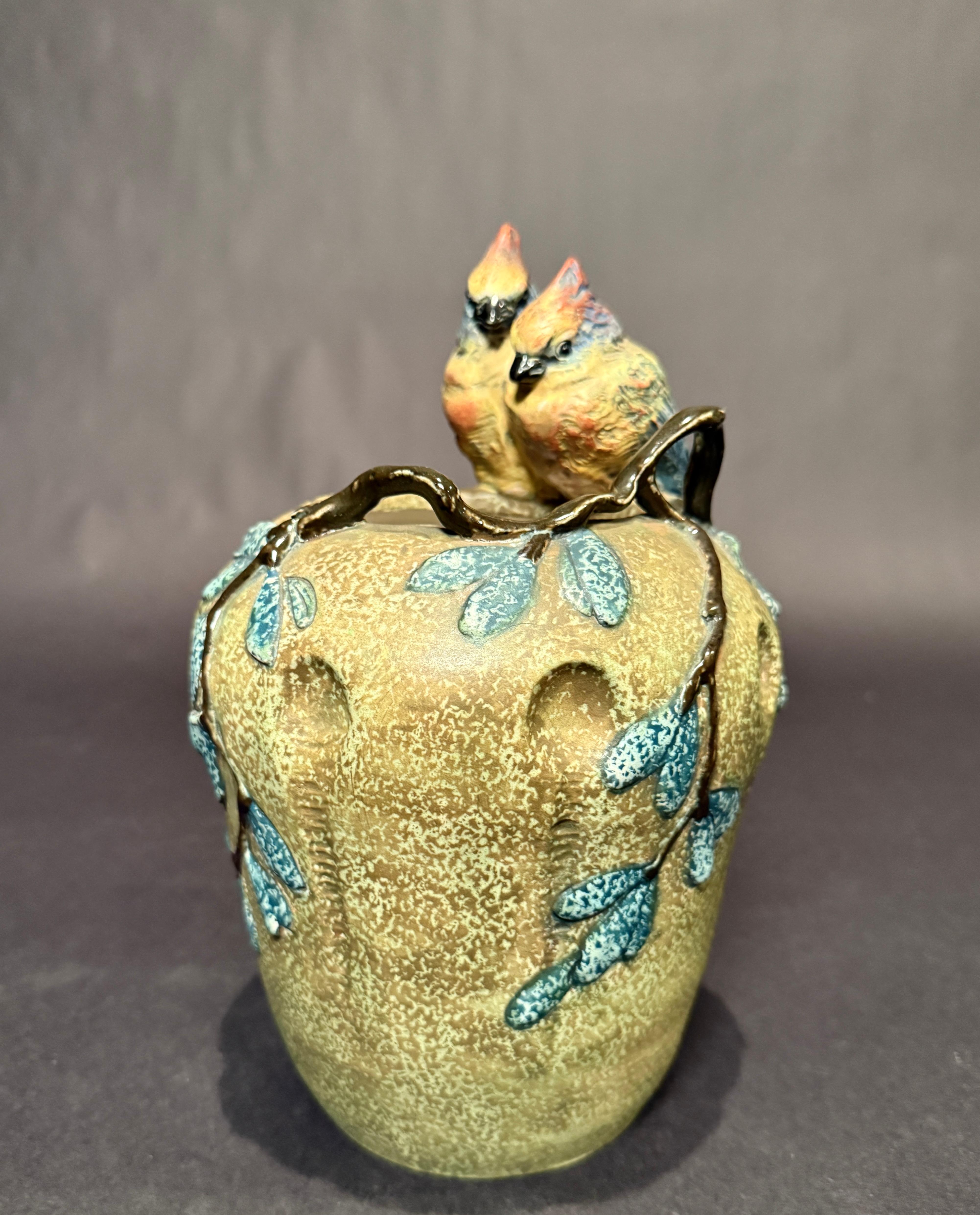 This is a wonderful quality example of Amphora pottery that features two full figural love birds that are perched on the top edge of the vase. Note the different glazes that bring wonderful contrast and beauty along with impressed and incised