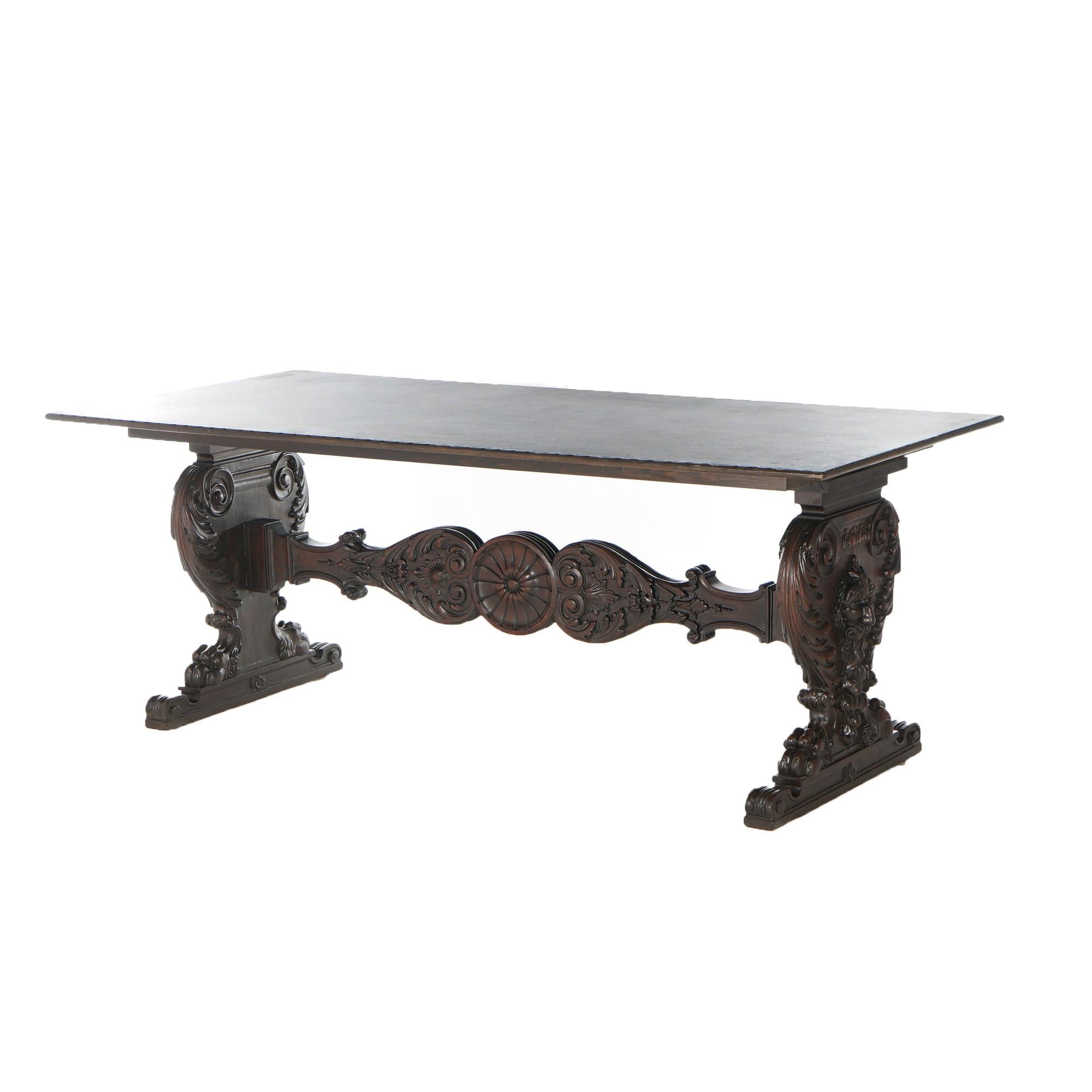 An antique figural banquet table offers oak construction with rectangular top over deeply carved foliate trestle legs with wind gods on the facing, c1890

Measures - 30.75
