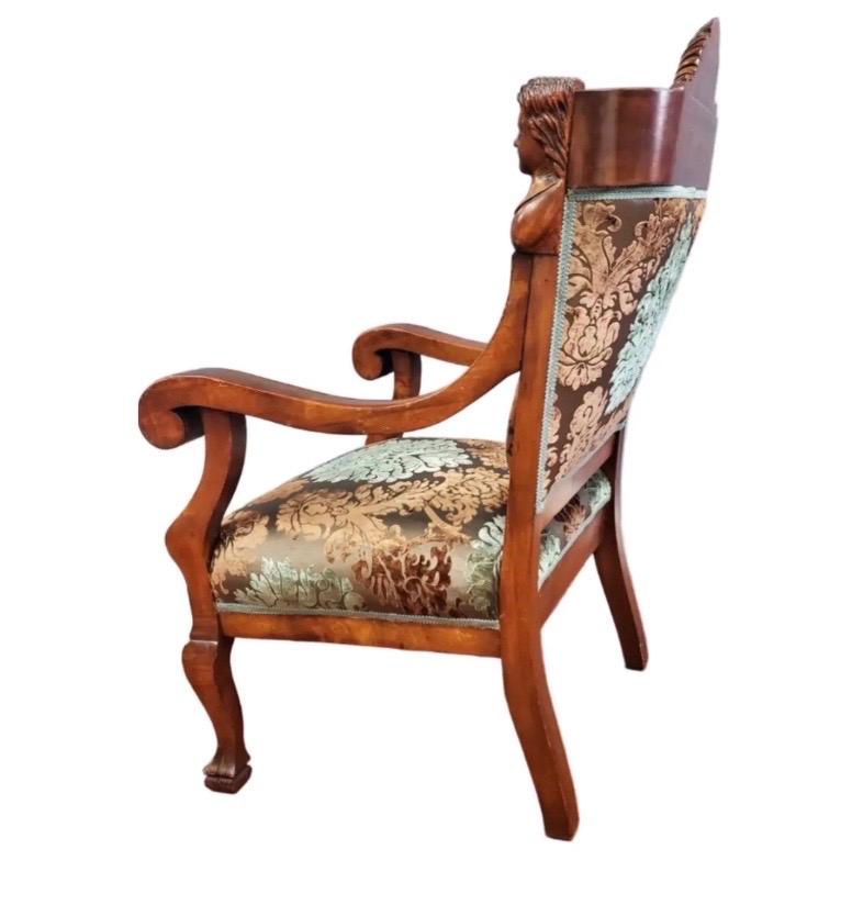 Questa magnifica poltrona antica della rinomata Karpen Furniture Co. è il massimo dell'artigianato e del lusso americano dei primi del Novecento. La cornice in legno massiccio è riccamente intagliata con dettagli figurativi, tra cui un elegante
