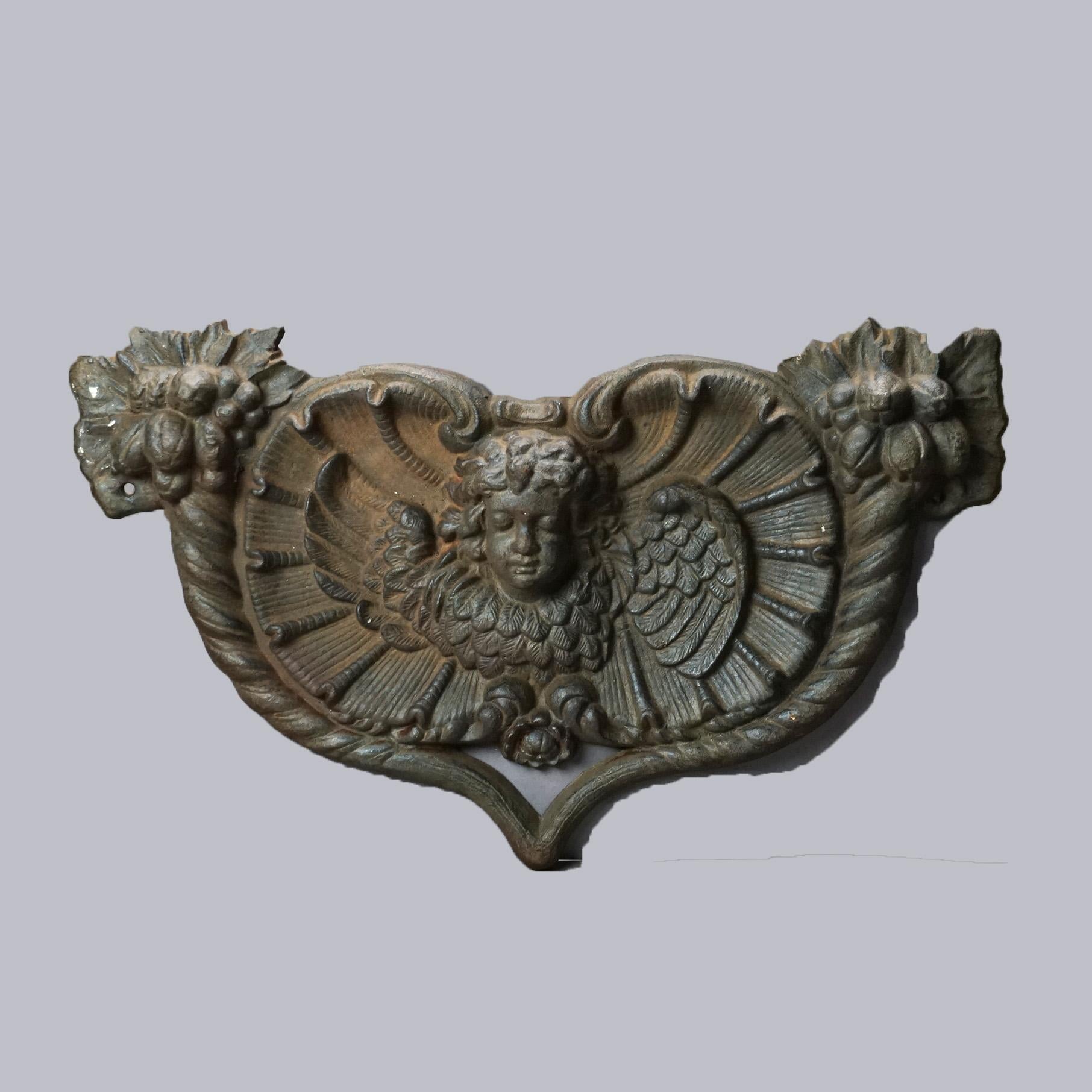 An architectural wall plaque offers cast iron construction in stylized heart form with embossed winged cherub, 20thC

Measures - 13'h x 21.5