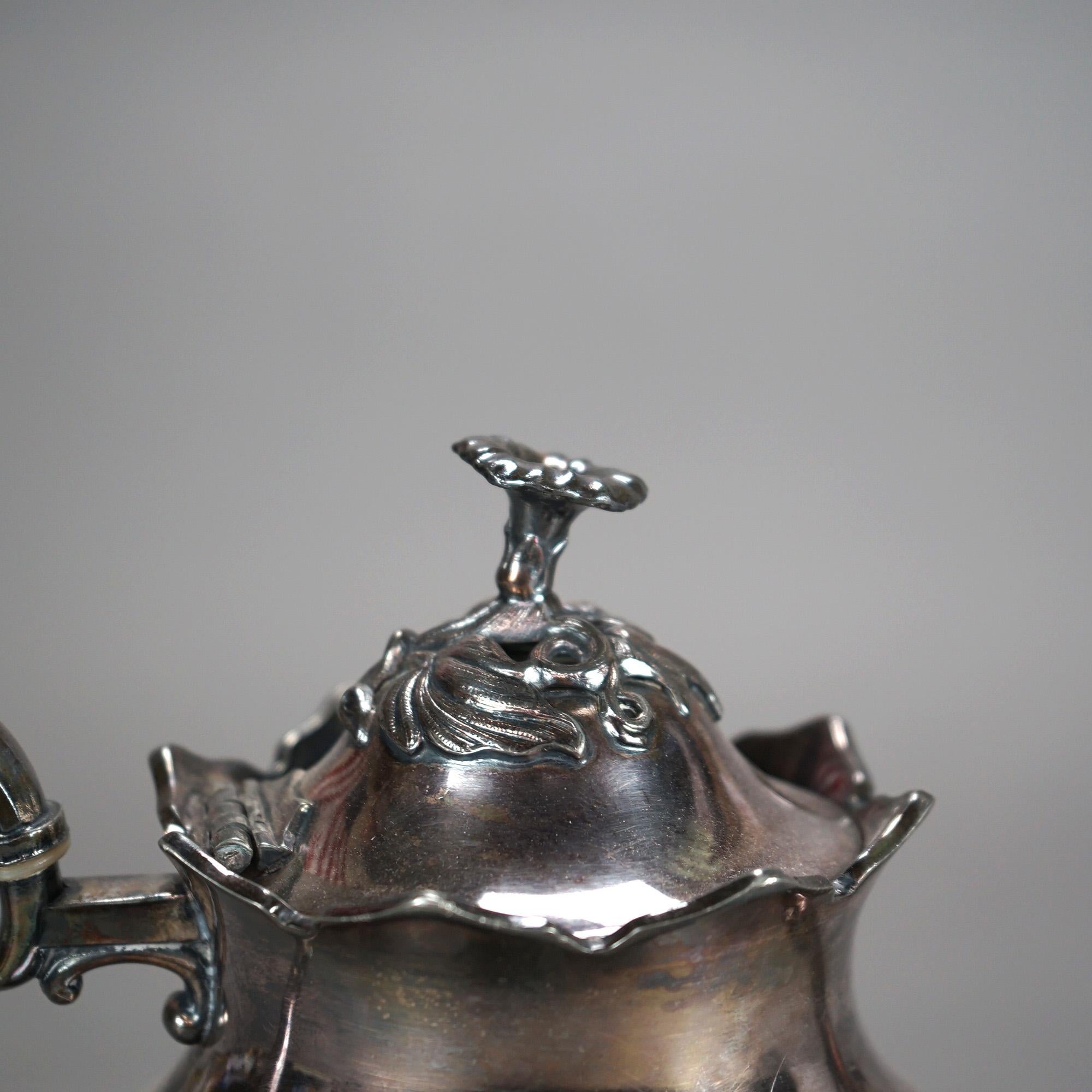 Théière ancienne en métal argenté avec gravure de feuillage et fleuron C1890

Mesures - 9,25 