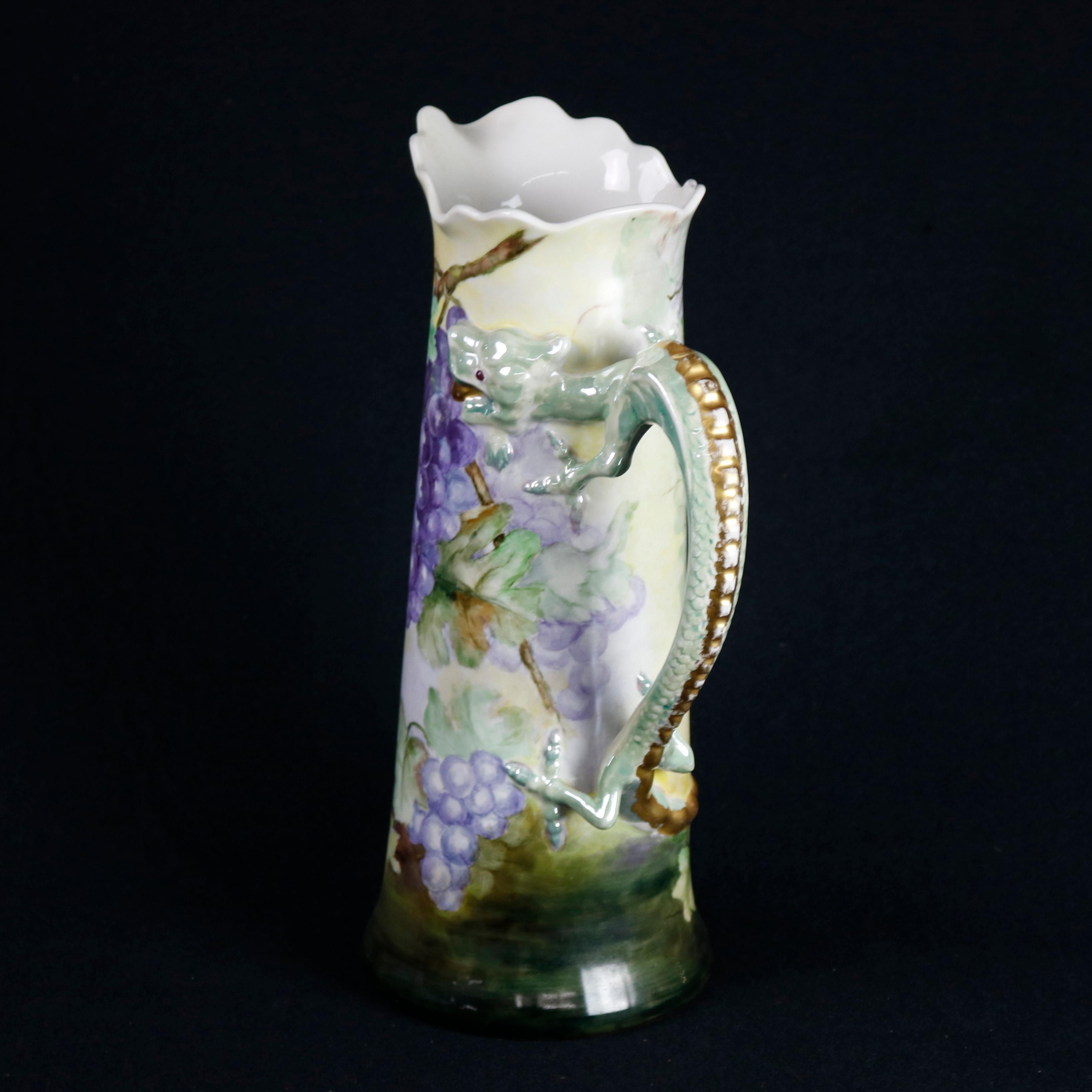A large antique French Jean Pouyat Limoges figural porcelain decorated tankard offers scalloped rim, figural dragon handle with gilt beaded spine, and all-over hand painted grape and leaf design with gilt highlights throughout, signed on base as