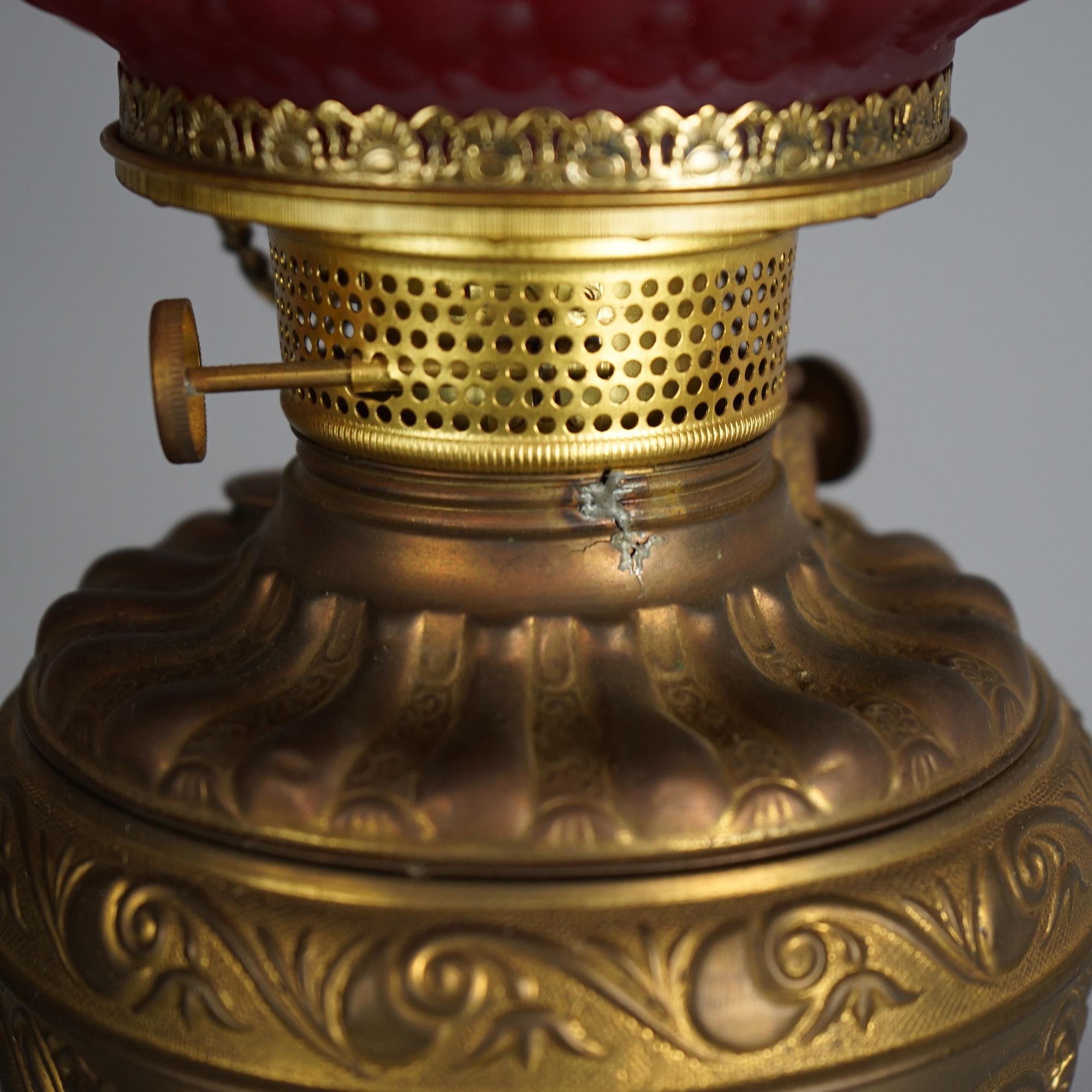 Cast Antique Figural Gilt Metal Parlor Lamp with Quilted Red Glass Shade Circa 1900 For Sale