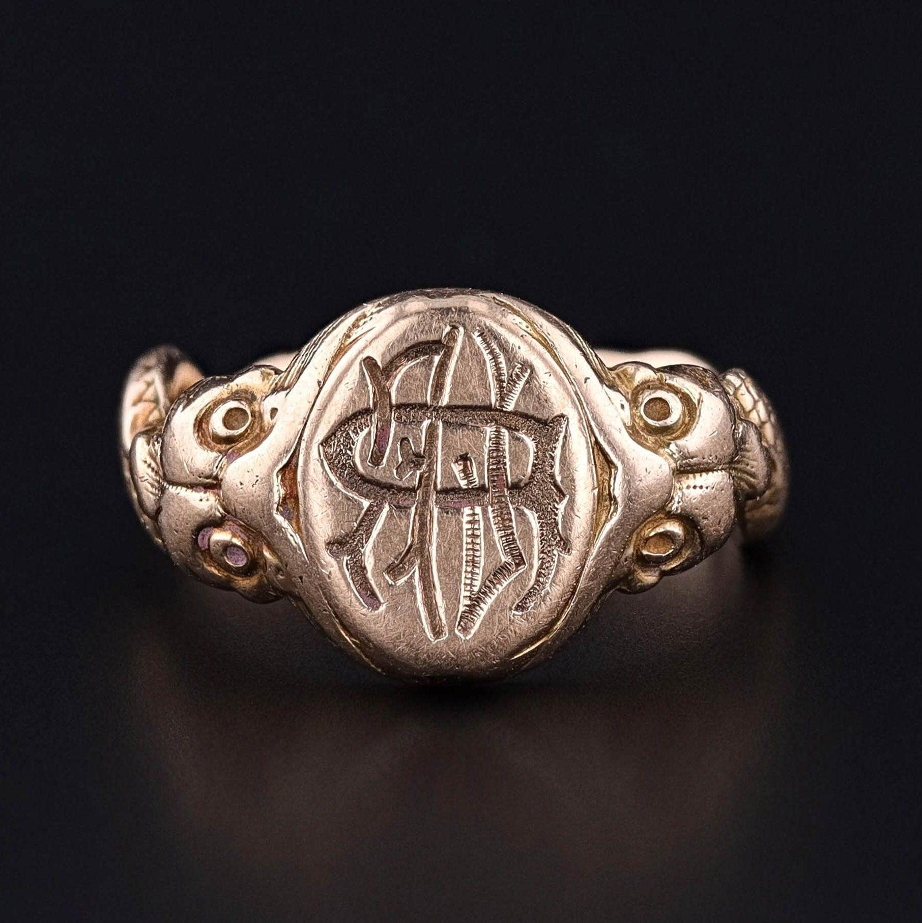 This antique 10k gold ring (circa 1890) features two fish on the shoulders of the band and a signet bearing the initials 'RLF' in reverse.

The face of the ring measures 0.45 inches by 0.4 inches wide and is in great condition. It is a size 5.25 but