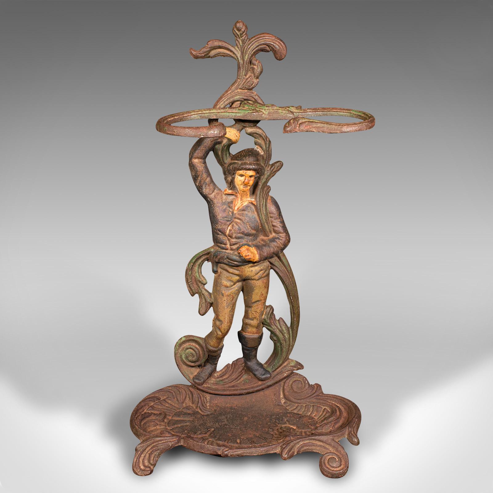 This is an antique figural umbrella stand. A French, painted cast iron decorative hall rack, dating to the late Victorian period, circa 1900.

Charming chap supports this stand in appealing fashion
Displays a desirable aged patina throughout
Cast