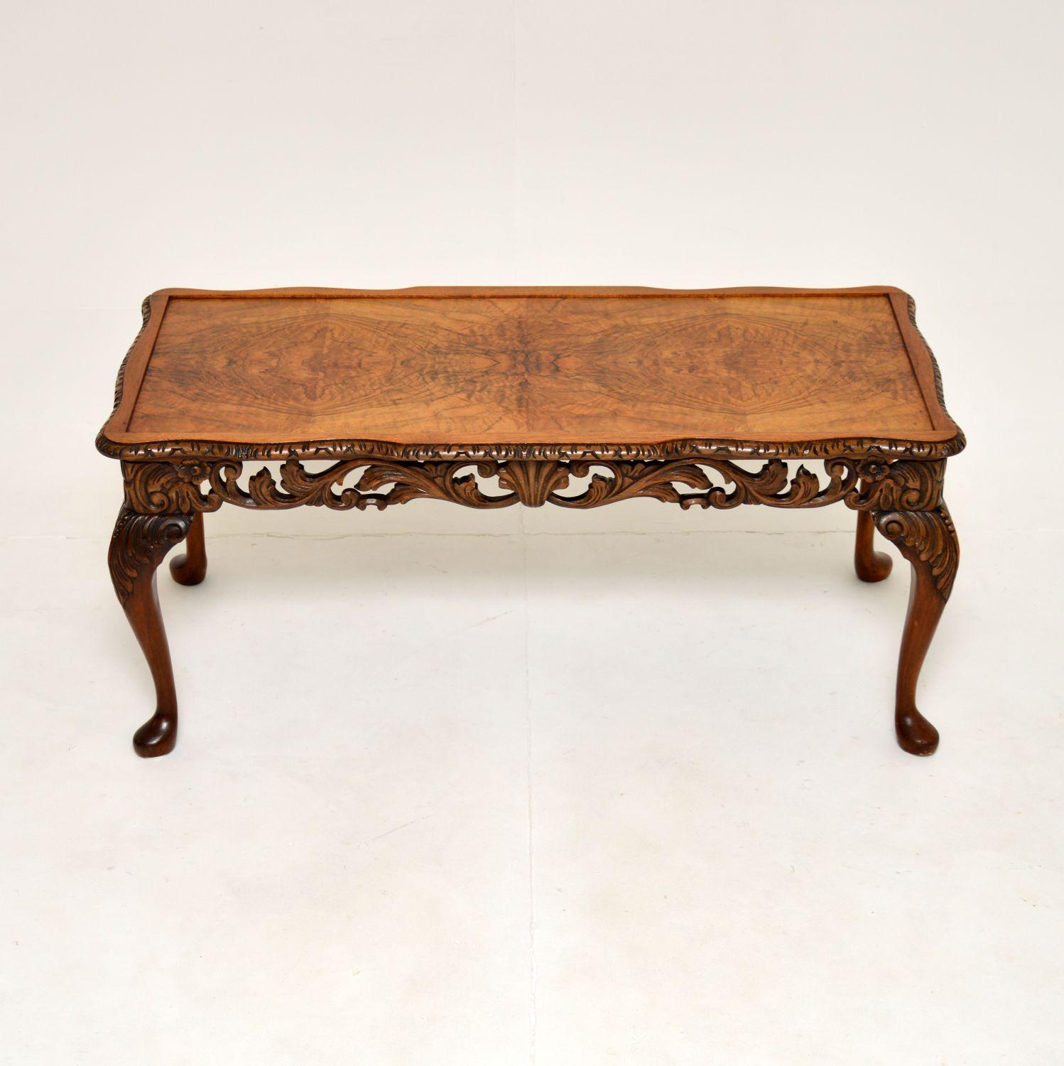 A beautiful and very well made antique figured walnut coffee table. This was made in England, it dates from around the 1920’s.

It is in the Queen Anne style, with gorgeous carving around the edges. It sits on cabriole legs with acanthus leaf