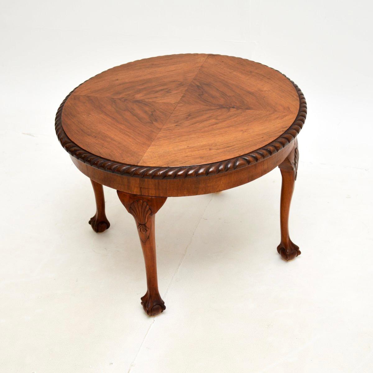 A lovely antique figured walnut coffee table in the Queen Anne style. This was made in England, it dates from around the 1930’s.

It is of wonderful quality, the circular top has beautiful grain patterns and gadrooned carving around the top edges.