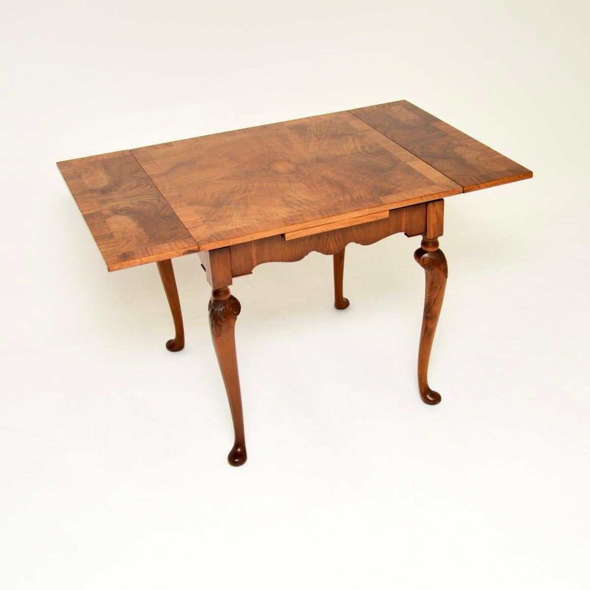 A fantastic antique figured walnut draw leaf dining table, made in England and dating from around the 1920’s.

This is of extremely fine quality and is a lovely size. There are two leaves stored beneath the top that slide out to turn this from a