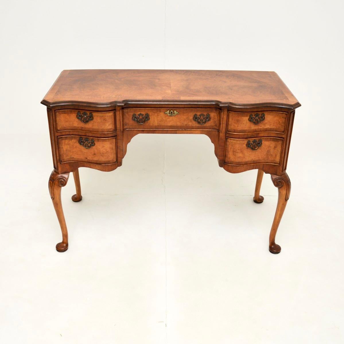 Superbe bureau ancien en noyer figuré de style Queen Anne. Fabriqué en Angleterre, il date d'environ la période 1900-1910.

La qualité est exceptionnelle, ce meuble est magnifiquement construit et possède un magnifique plateau en noyer figuré avec