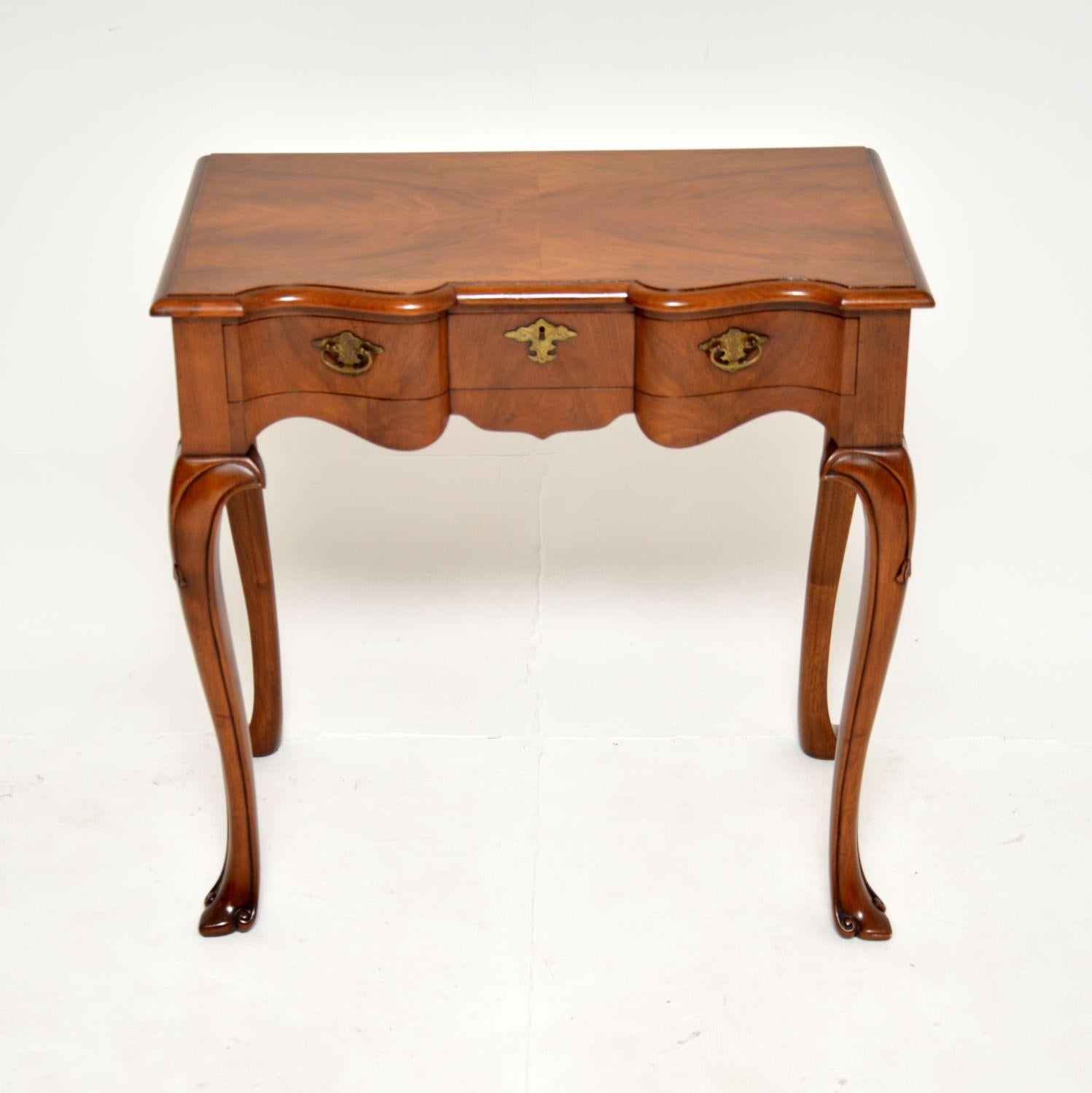 A beautiful and very useful antique walnut side table. This was made in England, it dates from around the 1930’s.

The quality is absolutely amazing, this is extremely well built and is a very practical size. The double serpentine shaped top sits