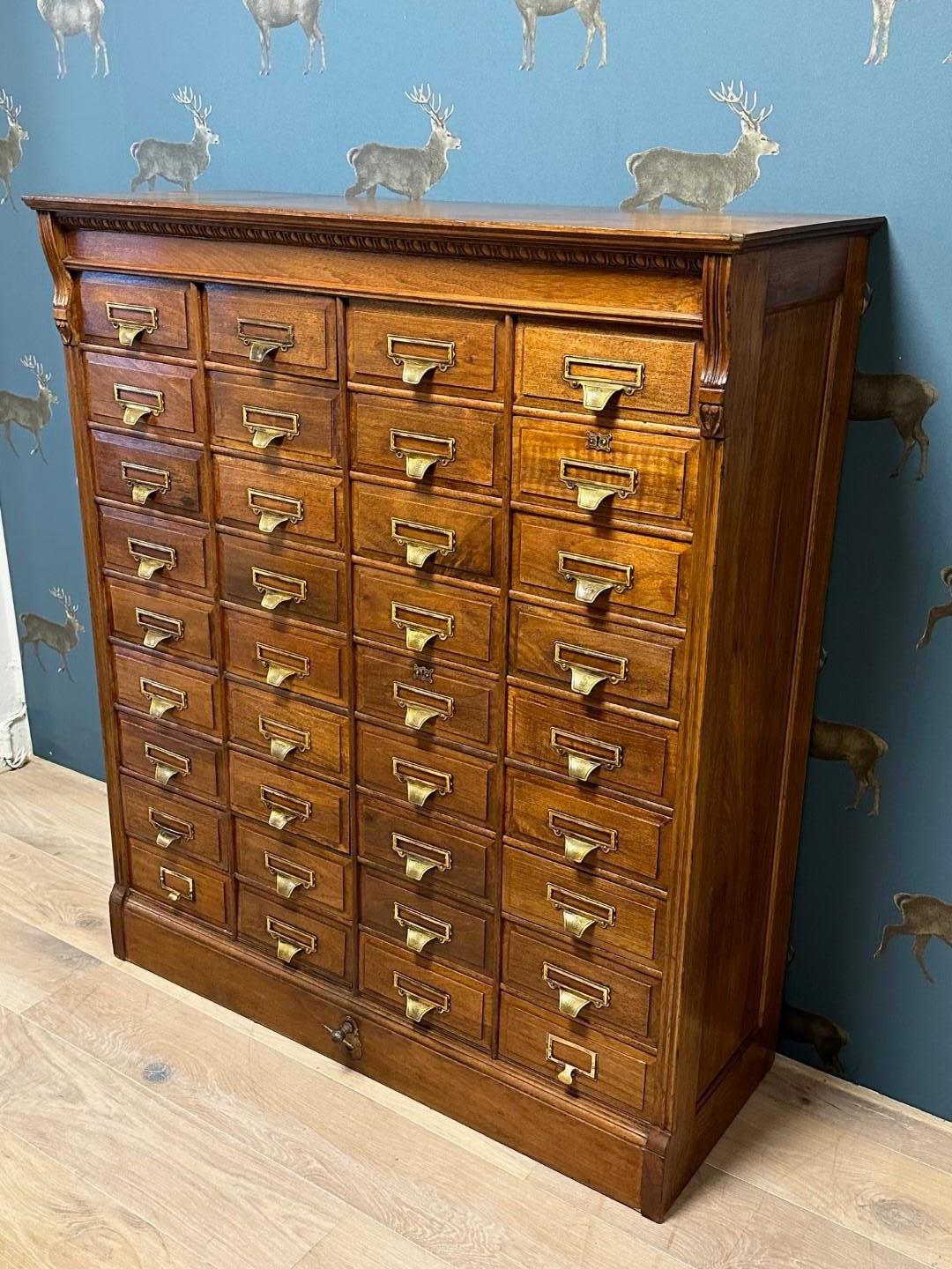 Antique walnut filing cabinet from the well-known company Shannon from the US. They also had a European branch in London. This is a filing cabinet with 36 drawers and lockable with a central latch (bottom center), key not present. The drawer pulls