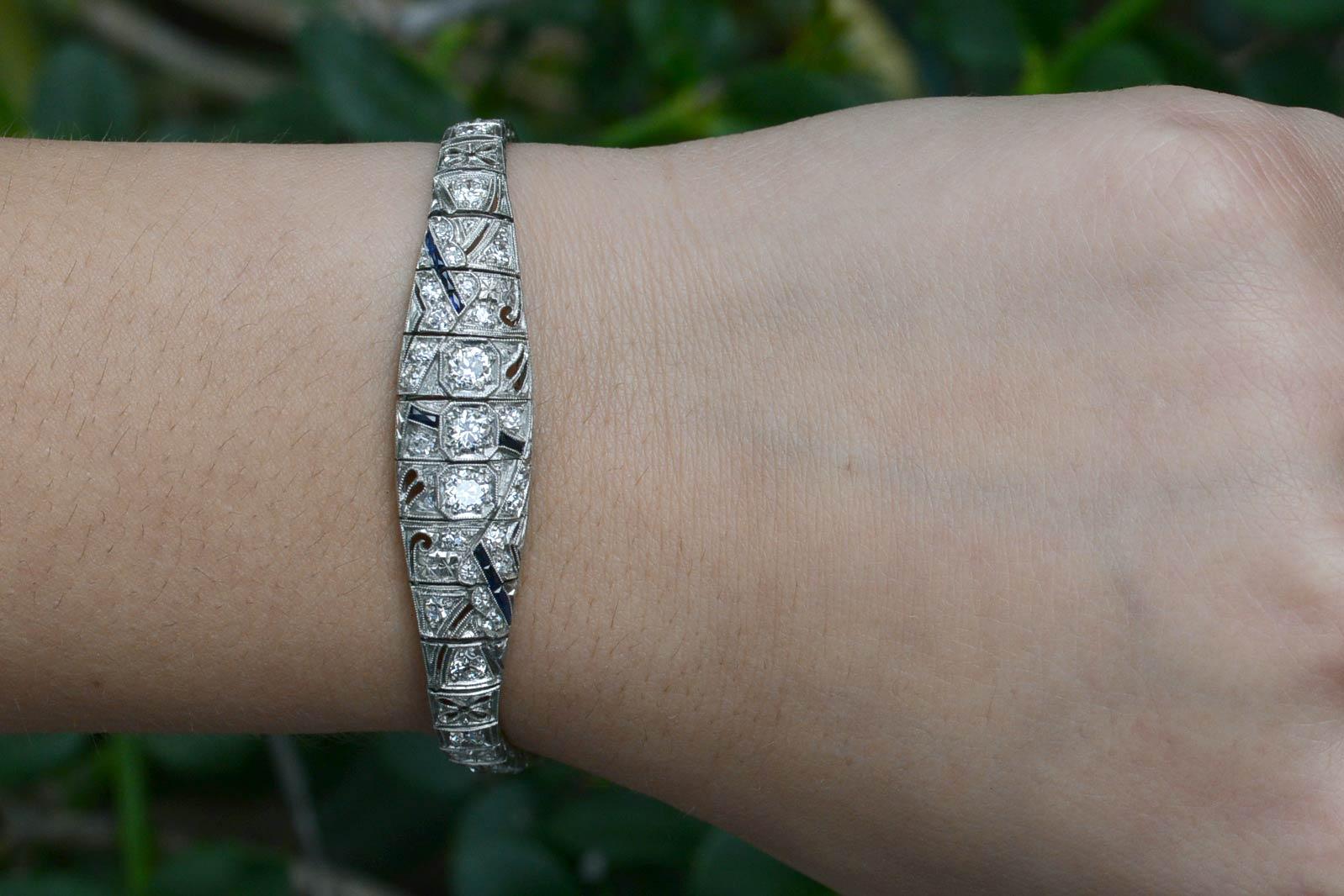 A sleek, geometric Art Deco platinum bracelet adorned with filigree and over 3 carats of fiery old European cut diamonds. These antique cuts with larger, chunky facets are so juicy and the links drape so softly on the wrist. The asymmetrical design