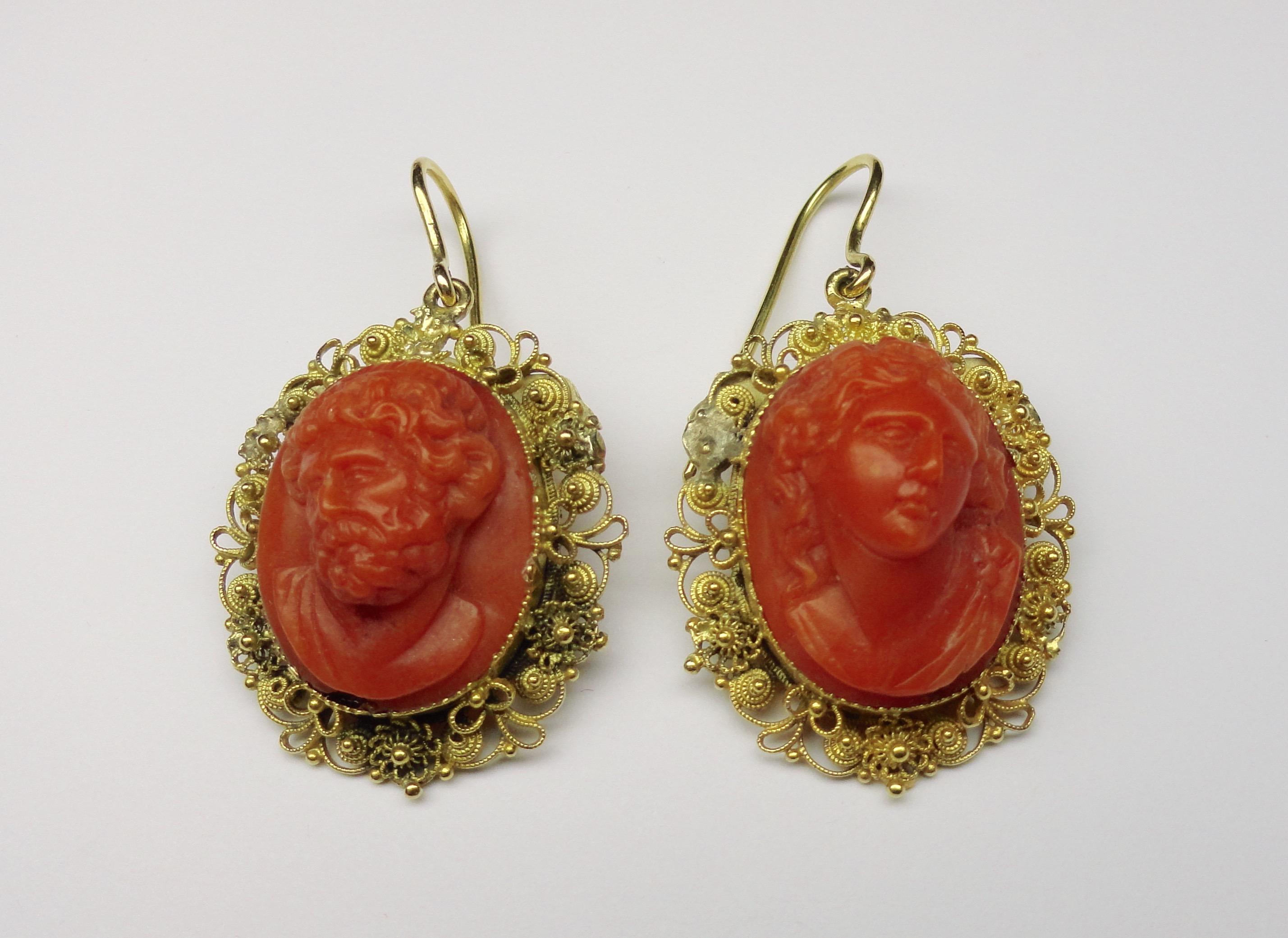 Antique earrings with coral cameos surrounded by gold filigree (18ct). With hinged hook fittings, Italian from the early 1900s.

Measurements: 4cm in length x 2.5cm in width