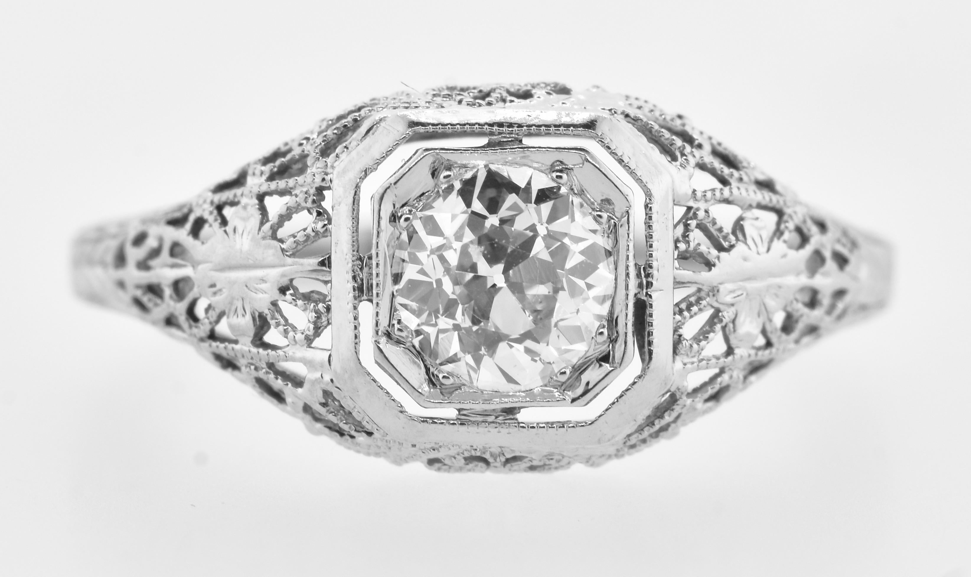 Antique filigree diamond 18K white gold ring.  The center European cut diamond weighs an estimated .65 cts.  It is near colorless (H/I) and very slightly included (VS).  This fine diamond is centered in a fine antique filigree 18K white gold ring. 