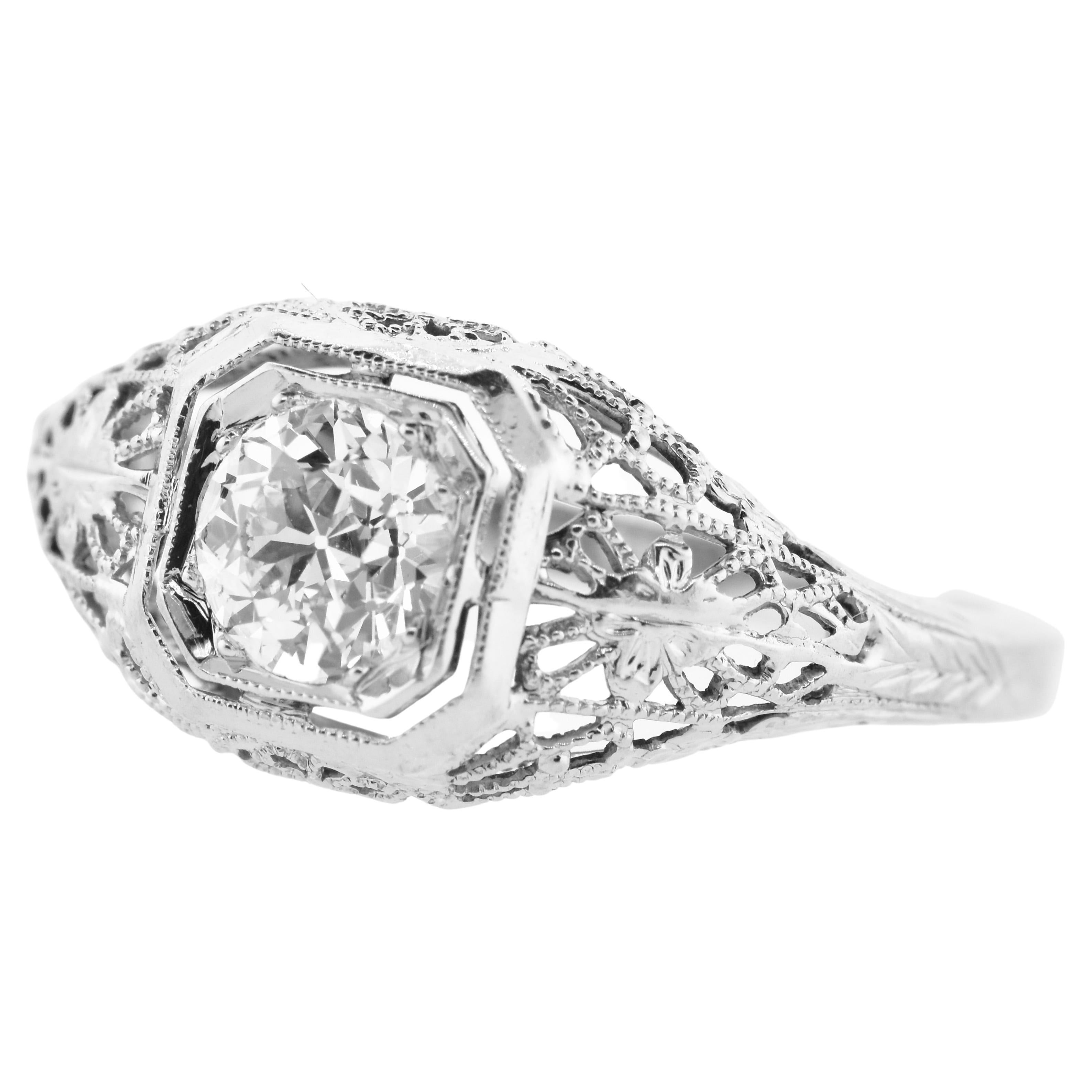 Antique filigree diamond 18K white gold ring.  The center European cut diamond weighs an estimated .65 cts.  It is near colorless (H/I) and very slightly included (VS).  This fine diamond is centered in a fine antique filigree 18K white gold ring. 