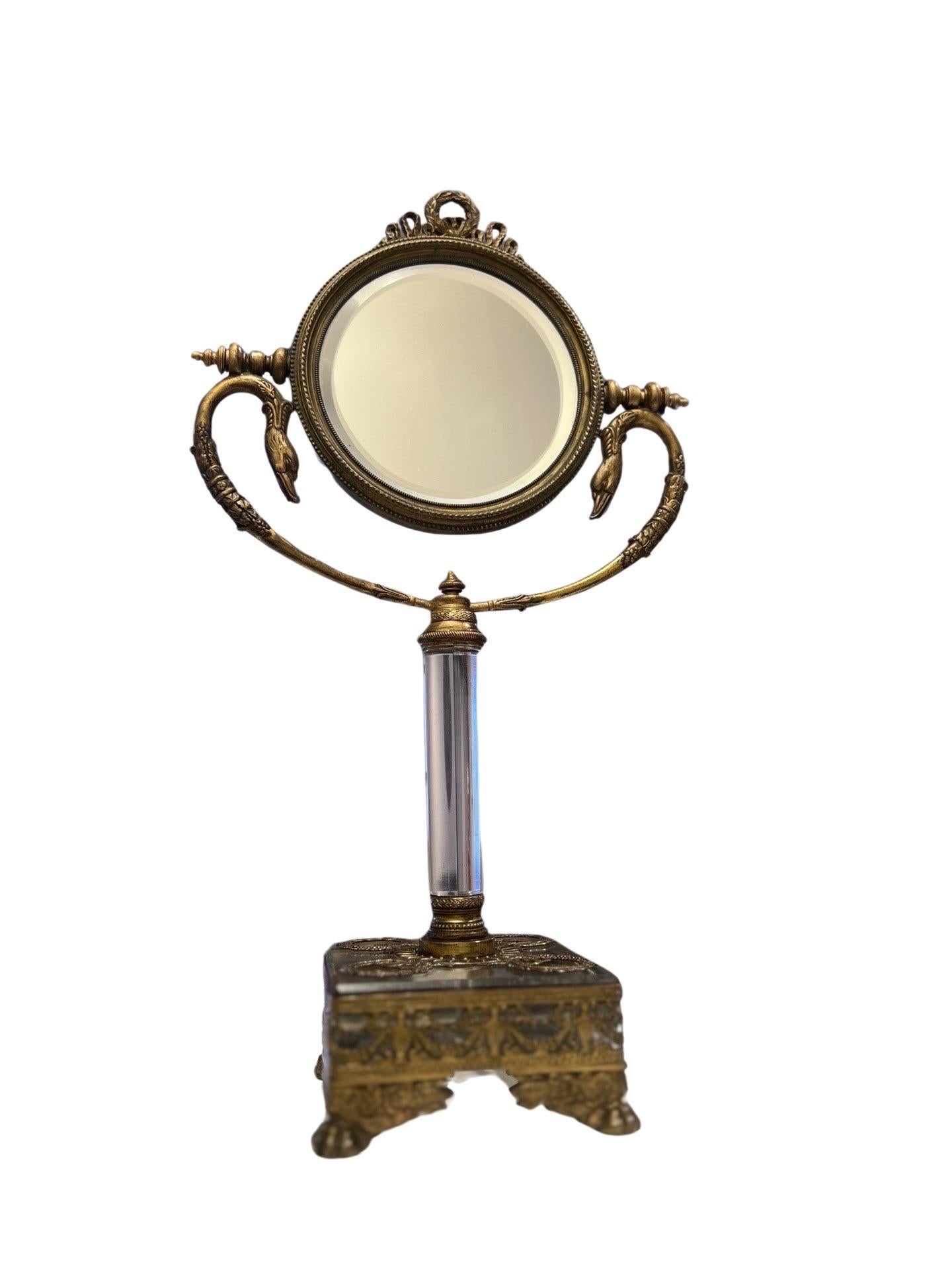 French, early to mid 19th century.

A stunning French Neoclassical vanity mirror. Atop the beautiful beveled glass (double sided) mirror is a laurel wreath finial, opposing swan head forms supports and acanthus leaf detailing. A central glass stem
