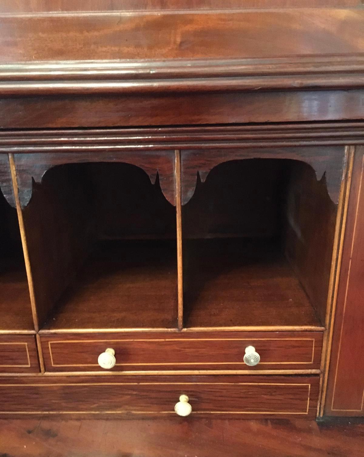 Fine quality Regency mahogany secretaire bookcase having an out swept reeded cornice above a brass inlaid frieze, a pair of quality mahogany panelled doors with reeded columns , original pierced brass escutcheons opening to reveal three adjustable