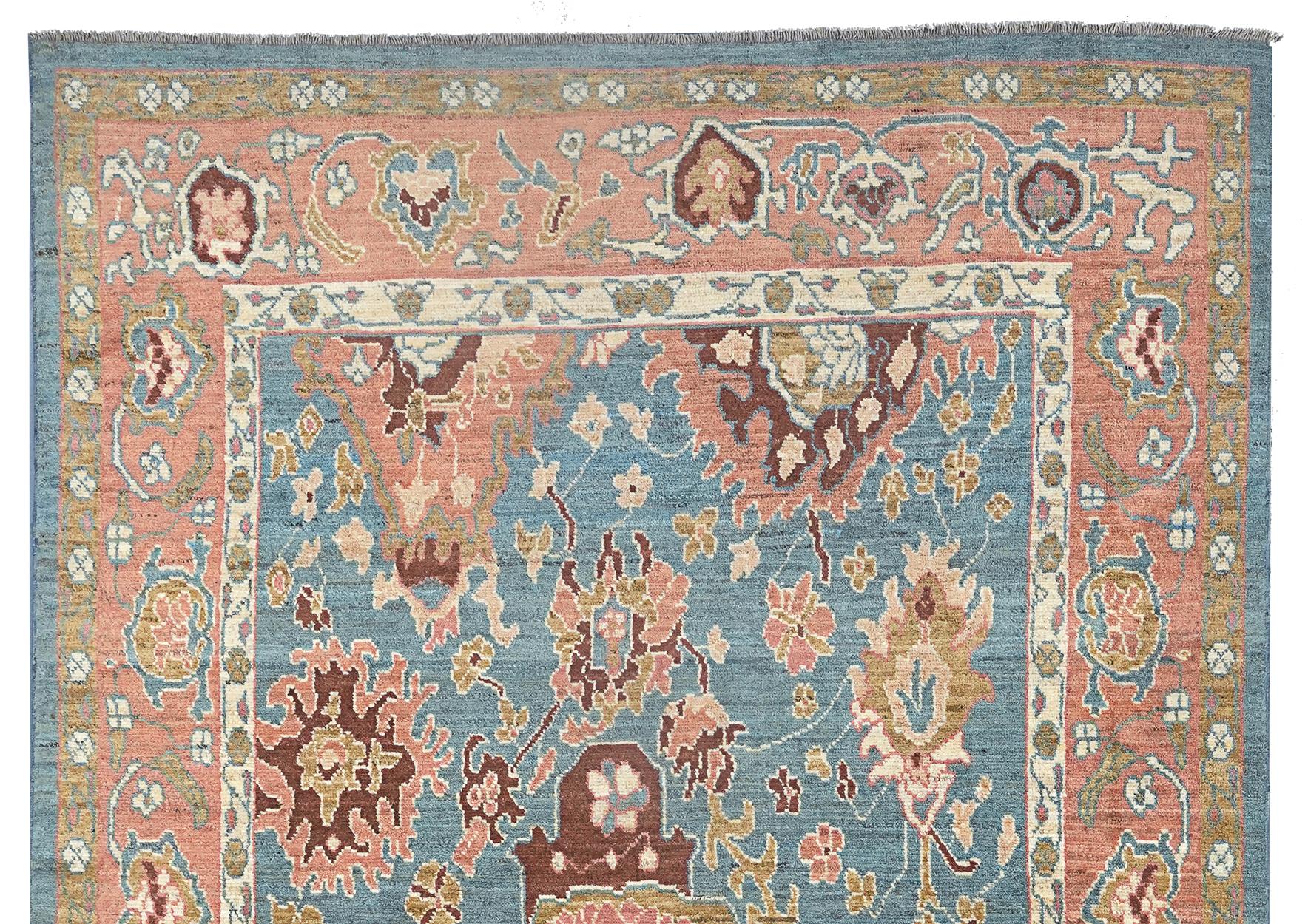 Dekorativer Ushak-Teppich mit einer beeindruckenden Farbpalette, die das Verlegen erleichtert. Der hellblaue Grund ist mit stilisierten Blumenköpfen verziert, die nach dem Zufallsprinzip in das Feld eingewebt sind und ihm so viel Charakter