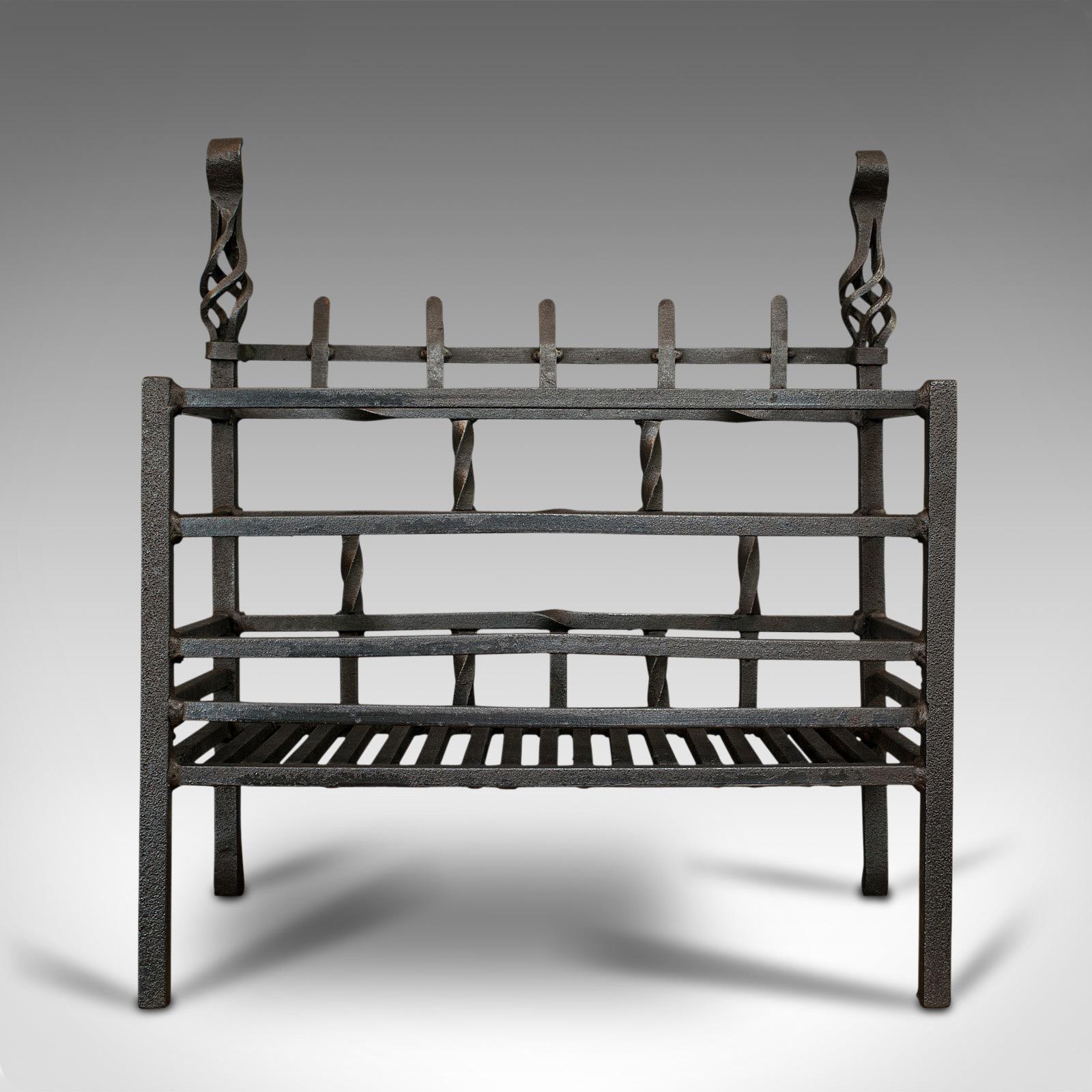 This is an antique fire basket. An English, cast iron fireside grate dating to the late Victorian period, circa 1900.

Practical grate with fine details
Displays a desirable aged patina
Cast iron with good, consistent graphite finish

Basket