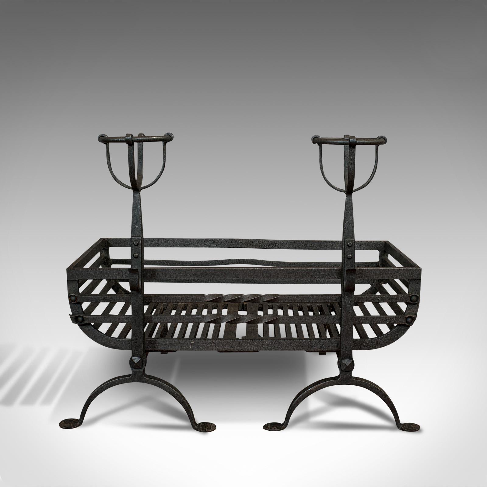 This is an antique fire basket and pair of andirons. An English, iron fireside suite, dating to the Victorian period, circa 1900.

Superb fire basket and dashing fire dog set
Displaying a desirable aged patina
Wrought iron basket offers a