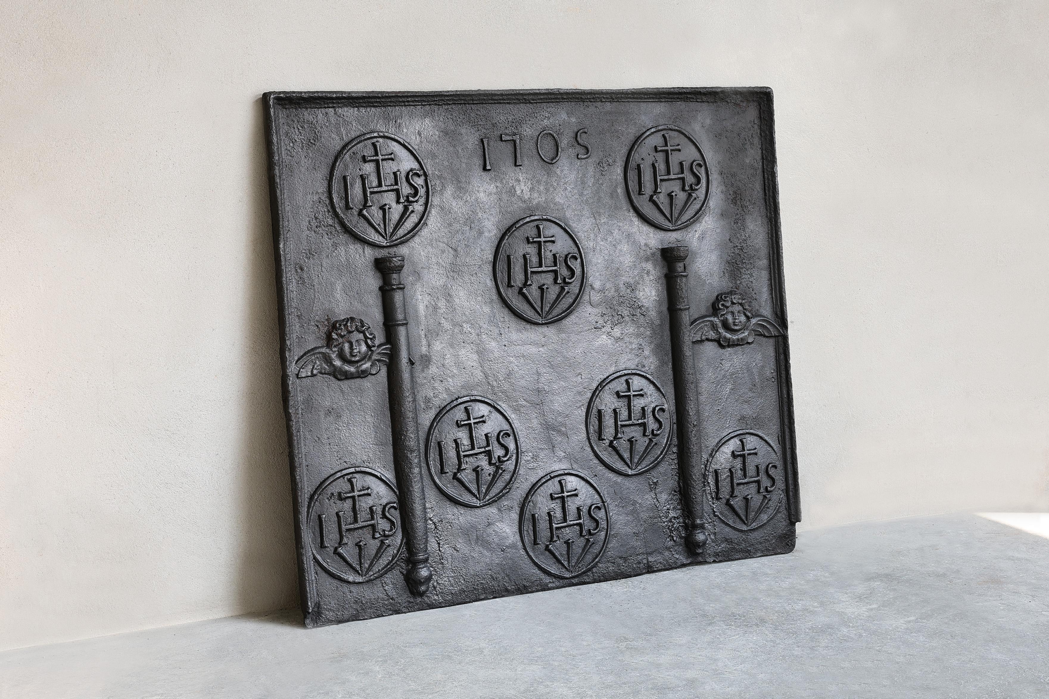 Très belle plaque de cheminée du début du 18e siècle en fonte. La particularité de cette plaque de cheminée est le signe HS (symbole de Jésus-Christ). C'est très rare et spécial !