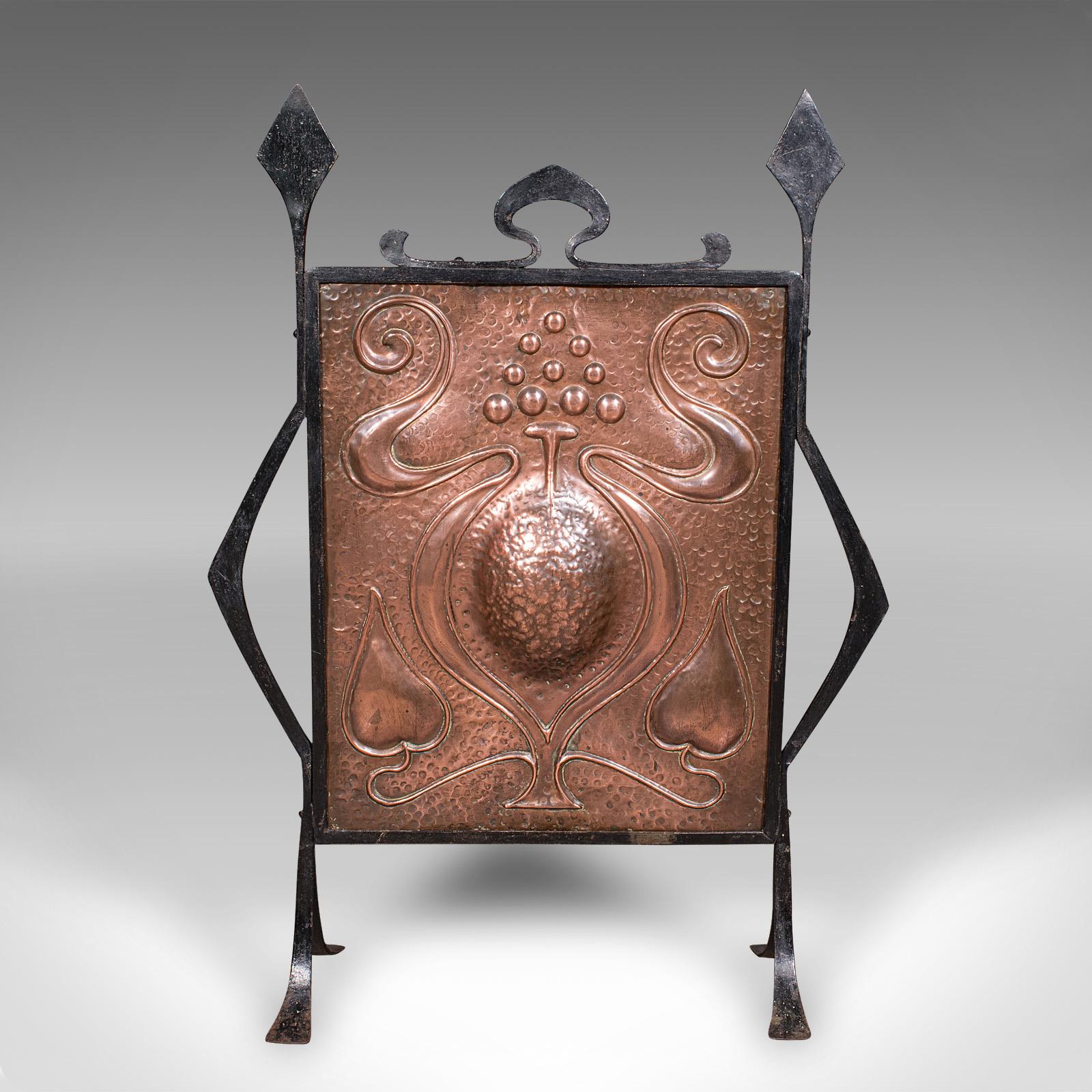 This is an antique fire screen. A French fireplace reflector in embossed copper and wrought iron, dating to the late Victorian period, circa 1900. A superb decorative piece, in the Art Nouveau taste with its flowing lines and floral