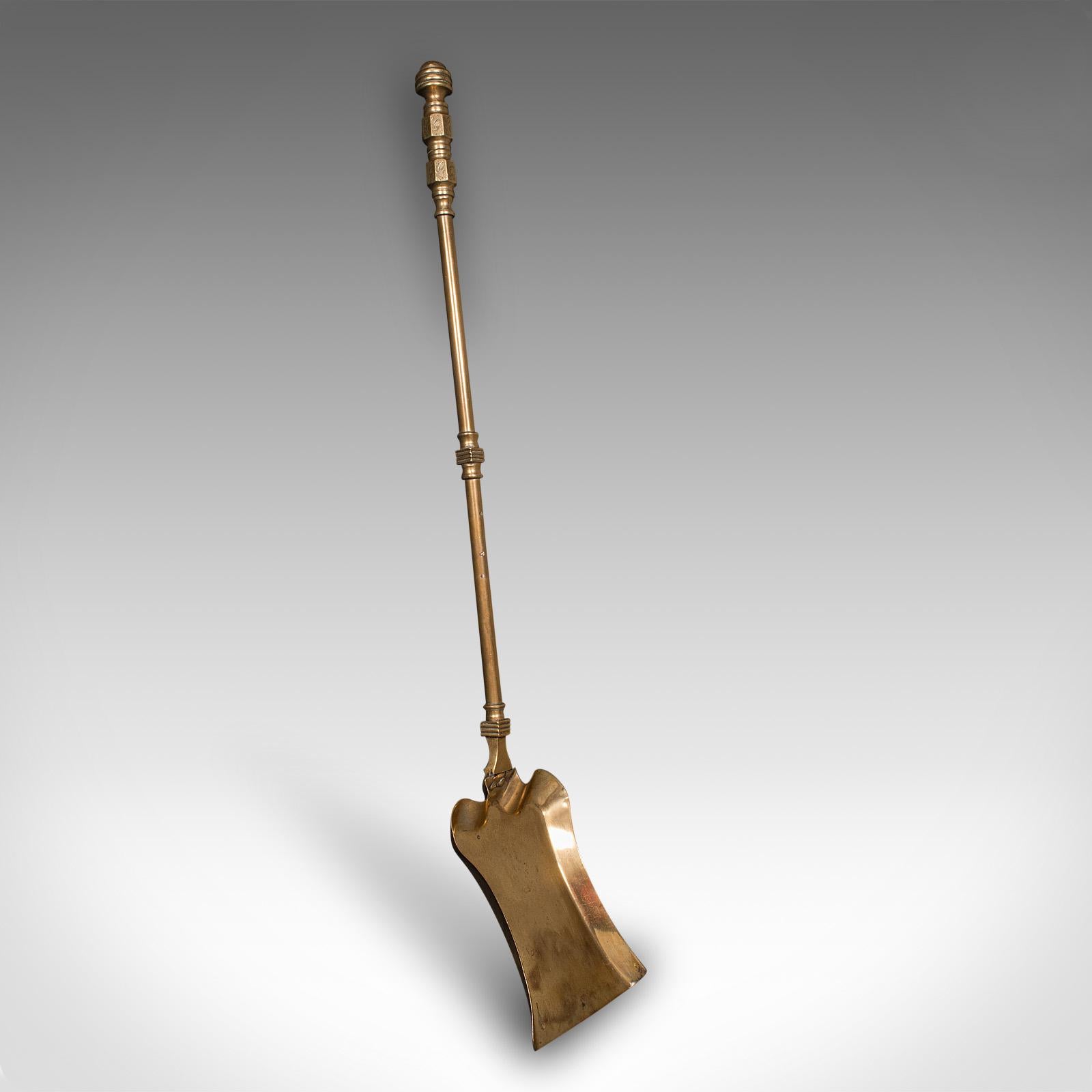 This is an antique fire tool set. An English, brass shovel, tongs and poker suite for the hearth, dating to the mid Victorian period, circa 1870. Presenting refined Victorian craftsmanship and decorative appeal, this elegant trio offers both