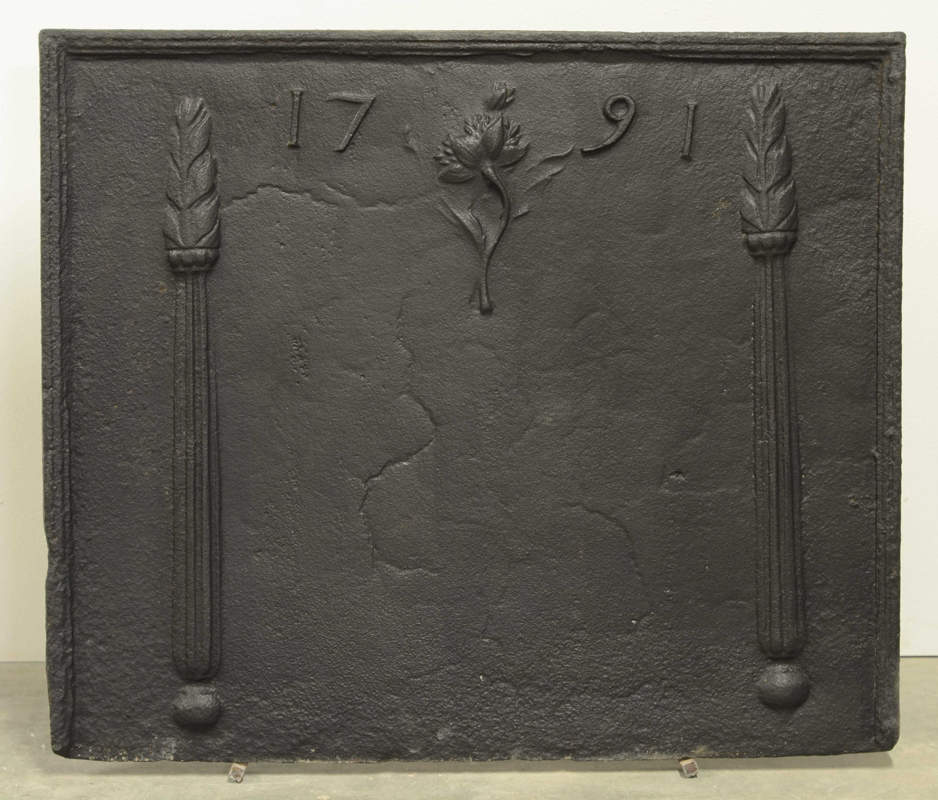 Beautiful 18th century antique cast iron fireback with two fire torches besides the date 1791 and a incredible flower in the centre.

Great original condition, perfect size.
Can be used as a fireback or backsplash.
 