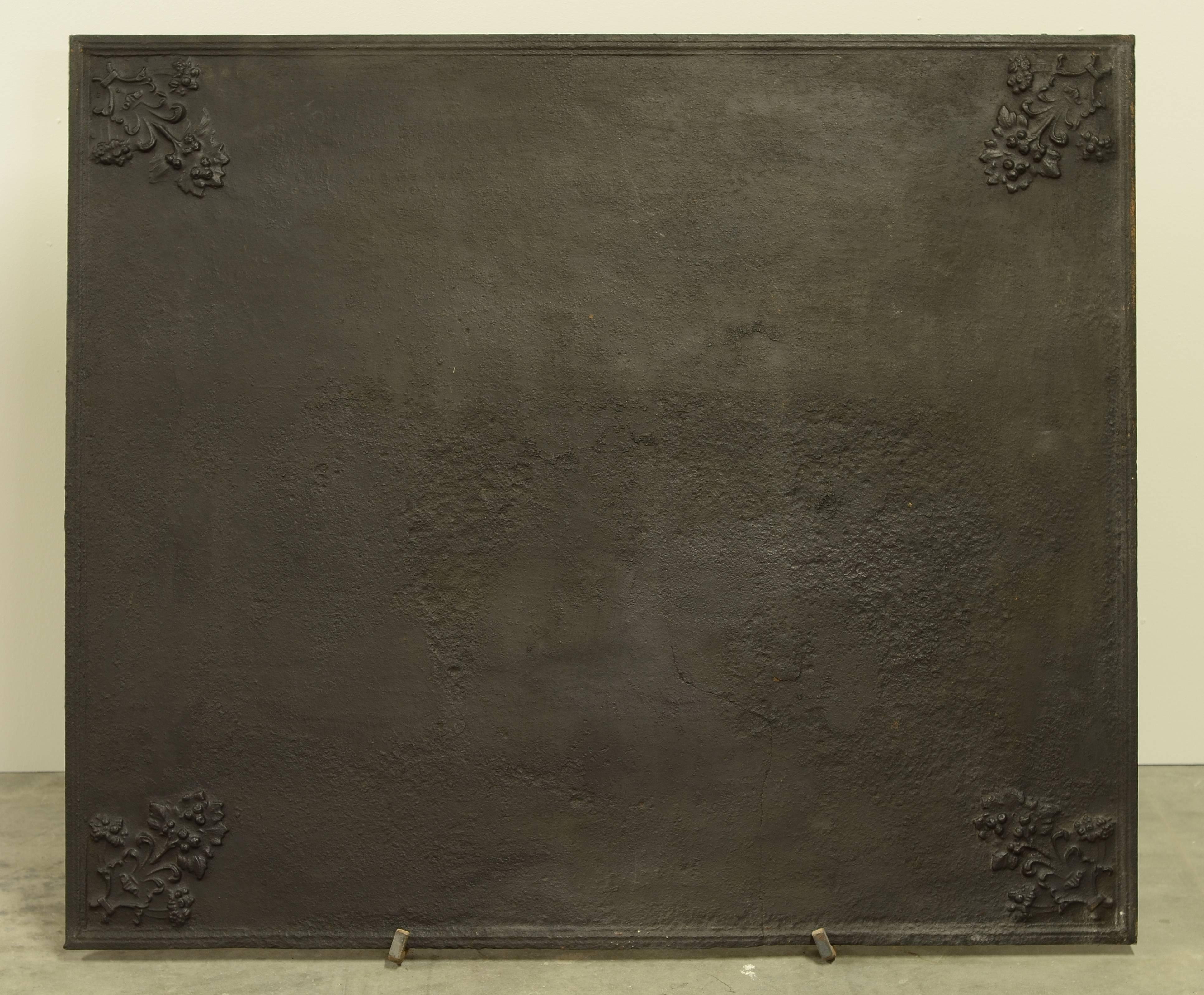 Large rectangular cast iron fireback with flowers in every corner.

Great usable size, small crack in the bottom. (see pictures)
To be used as a backsplash.
Can be supplied with stand.
