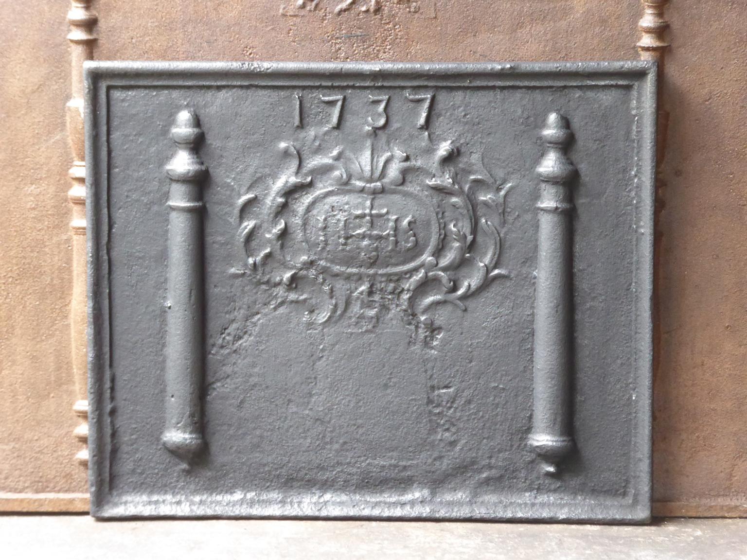 18th century French Louis XIV fireback with a IHS monogram and the date of production 1744. The monogram IHS stands for Iesus Hominum Salvator (Jezus the Savior of Humanity) or In Hoc Signo (In this sign will you win).

The fireback is made of