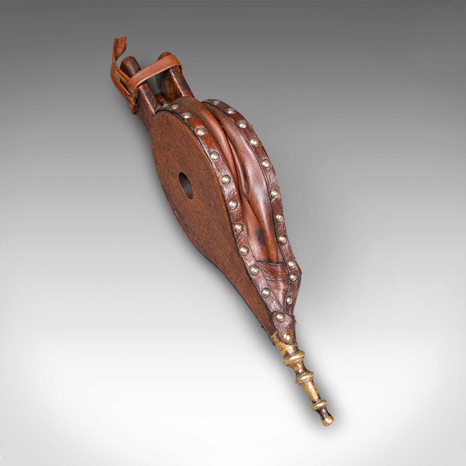 Questo è un antico soffietto per caminetto. Strumento inglese per accendere il fuoco, in quercia e pelle, risalente al tardo periodo vittoriano, circa 1880. Meravigliosamente conservato, combina la pratica funzione di illuminazione del fuoco con una