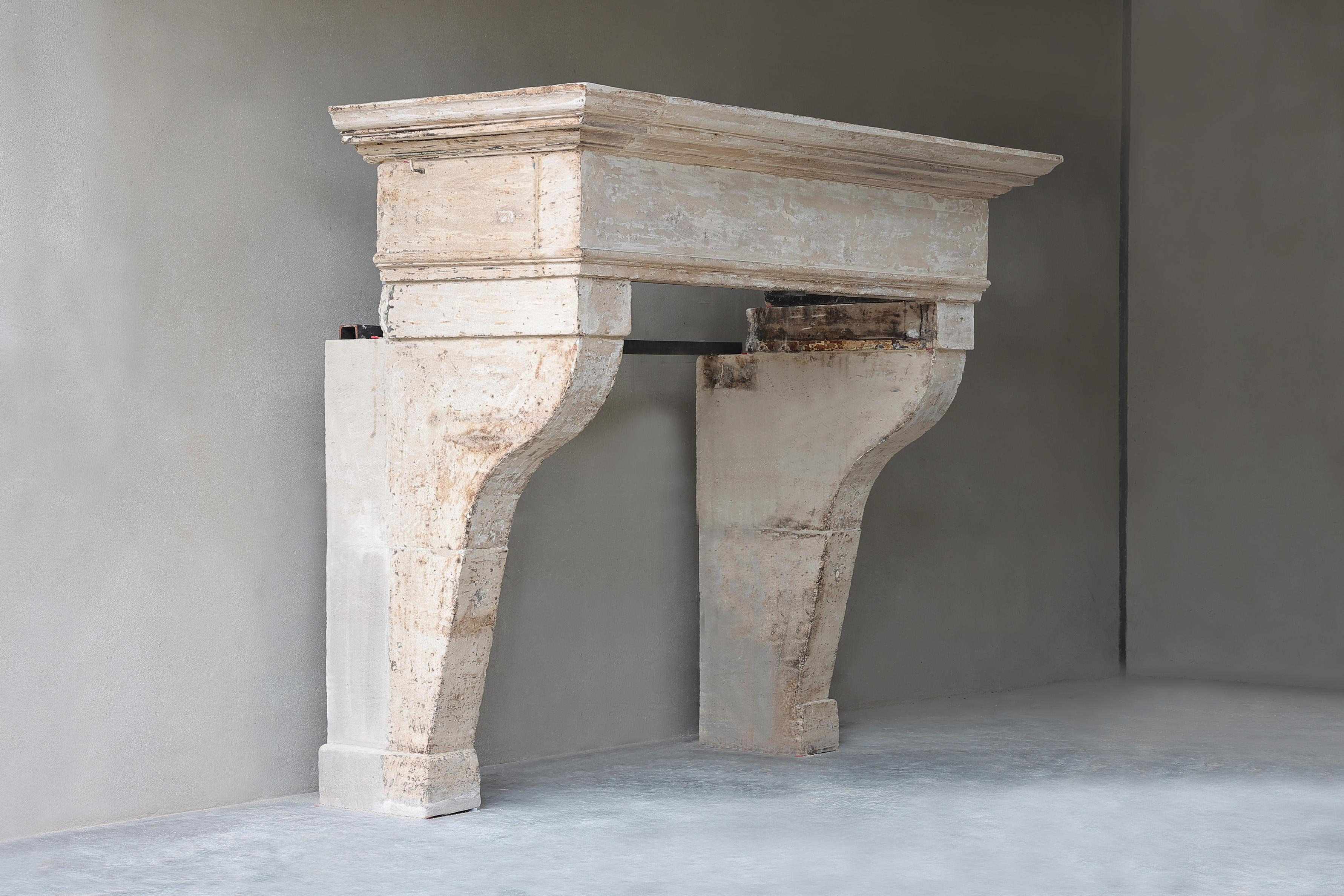 This antique castle mantelpiece made of French limestone dates from the 18th century and is in the style of Louis XIII. An imposing fireplace with a wide front section and slightly curved legs and molding. This fireplace has a very stately and