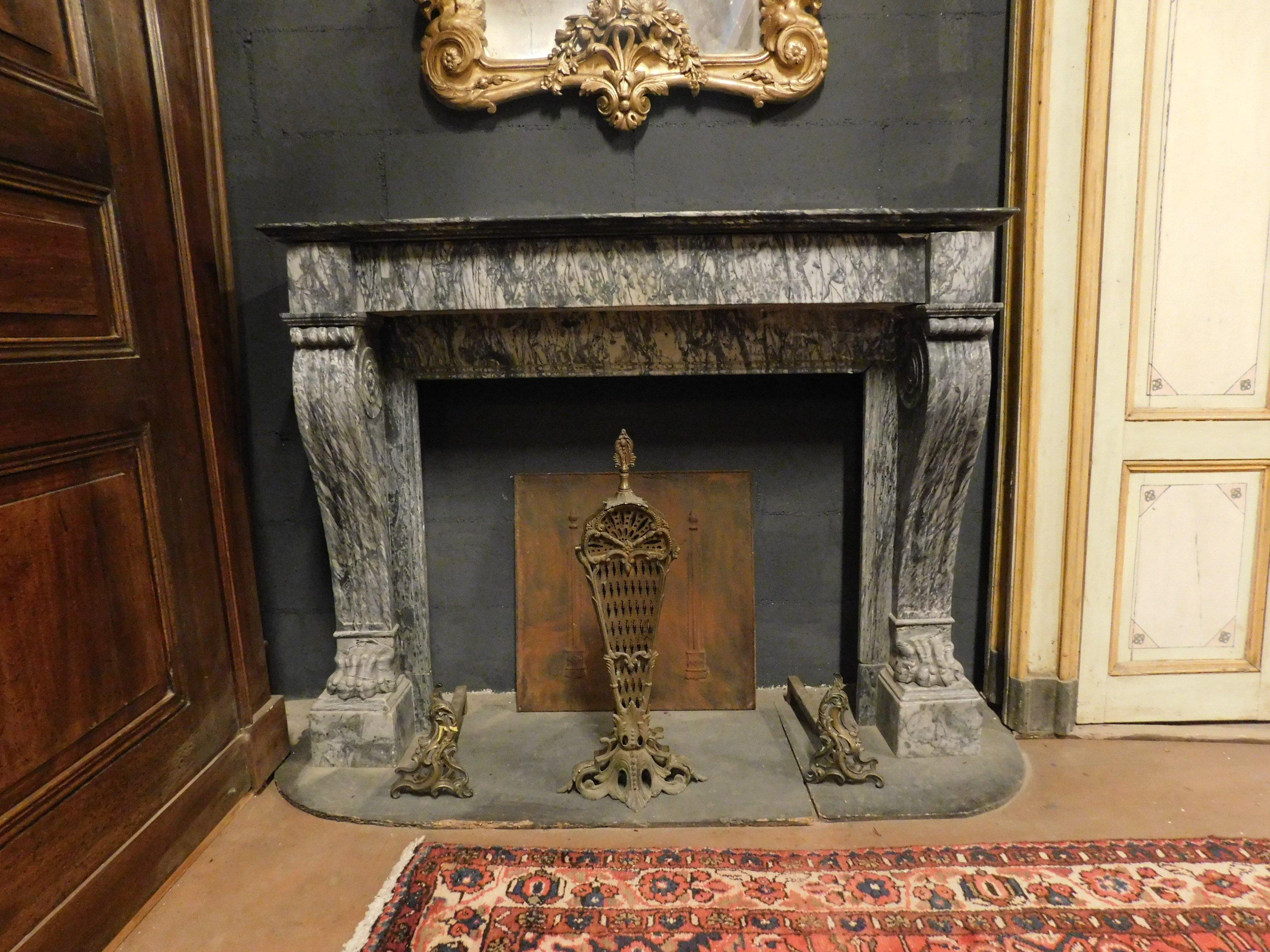 Antique fireplace mantel in gray marble hand carved by an Italian artist, with lion's feet and wavy columns, Empire style, early 1800s, from an Italian noble home. Thanks to its refined color and its gentle shape, it lends itself to all those