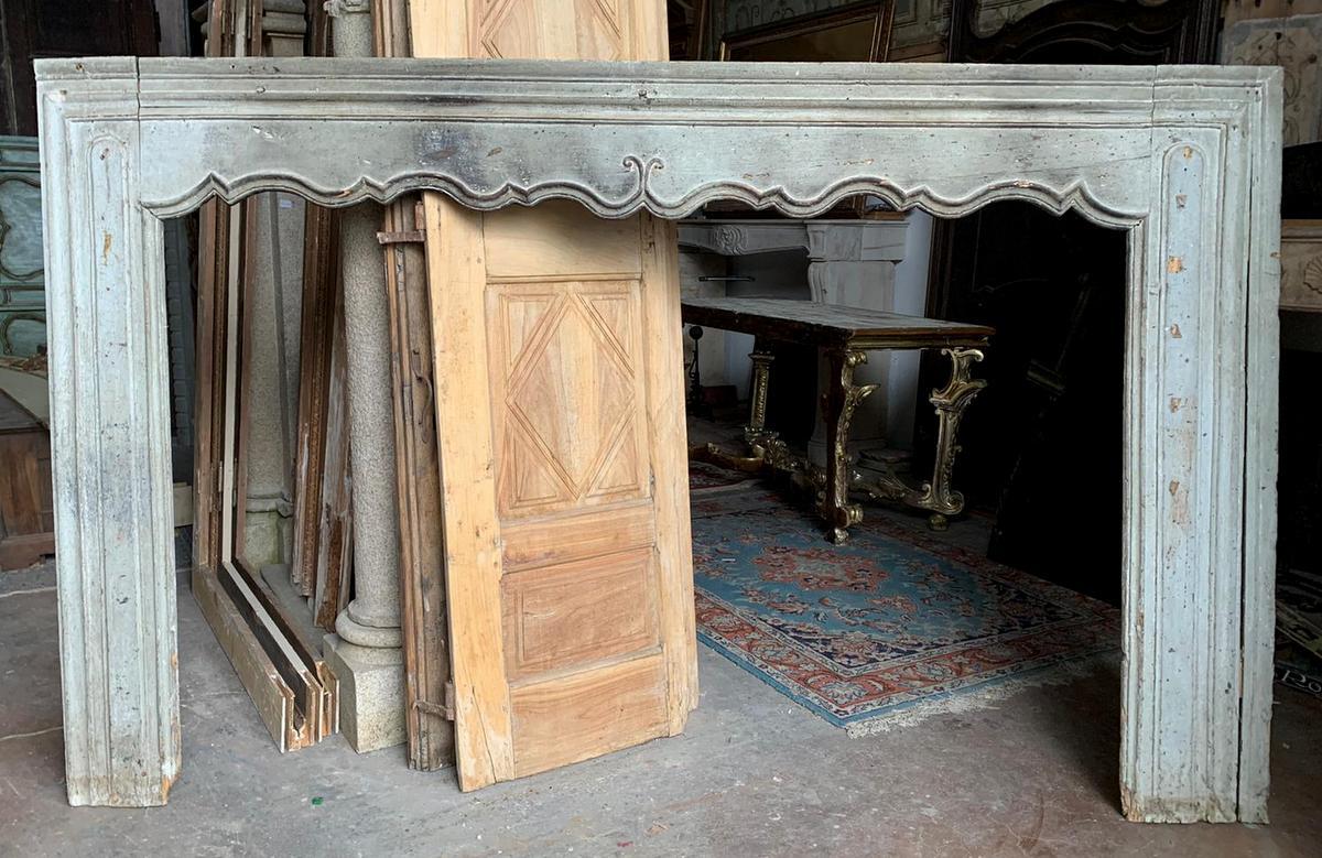 Antique mantel fireplace, hand-carved in gray lacquered wood, with moved mouth shape and beautiful original antique patina, hand-built in the first half of the 18th century, for home in Italy.
Fascinating and sparkling with history, it will