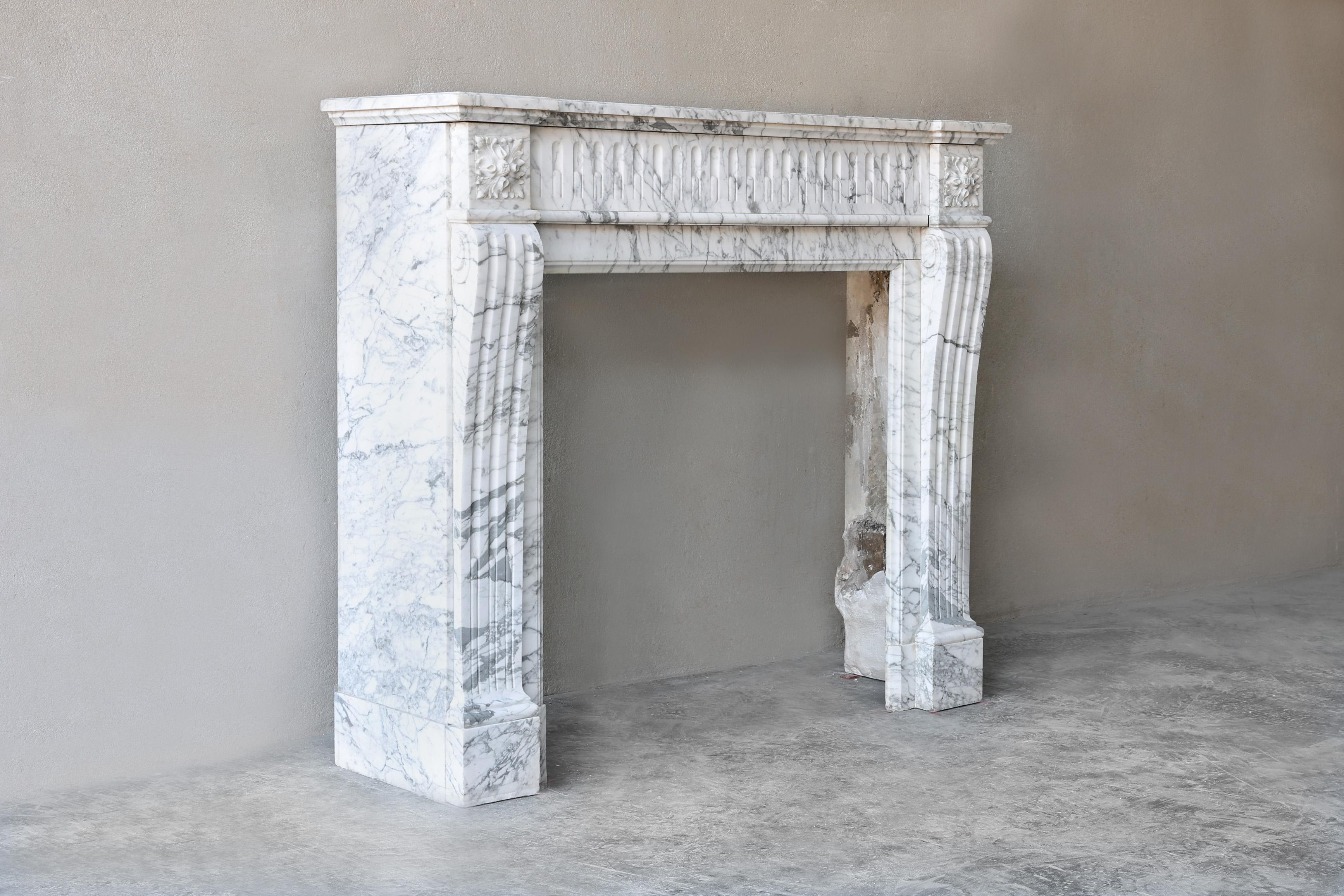 Eleganter antiker Kamin aus Arabescato-Marmor aus dem 19. Jahrhundert. Dieser Kaminsims im Louis XVI-Stil hat viele Kanneluren an der Vorderseite und an den Beinen! Auch die Ornamente verleihen dem Kamin eine gewisse Anmut. Arabescato-Marmor stammt