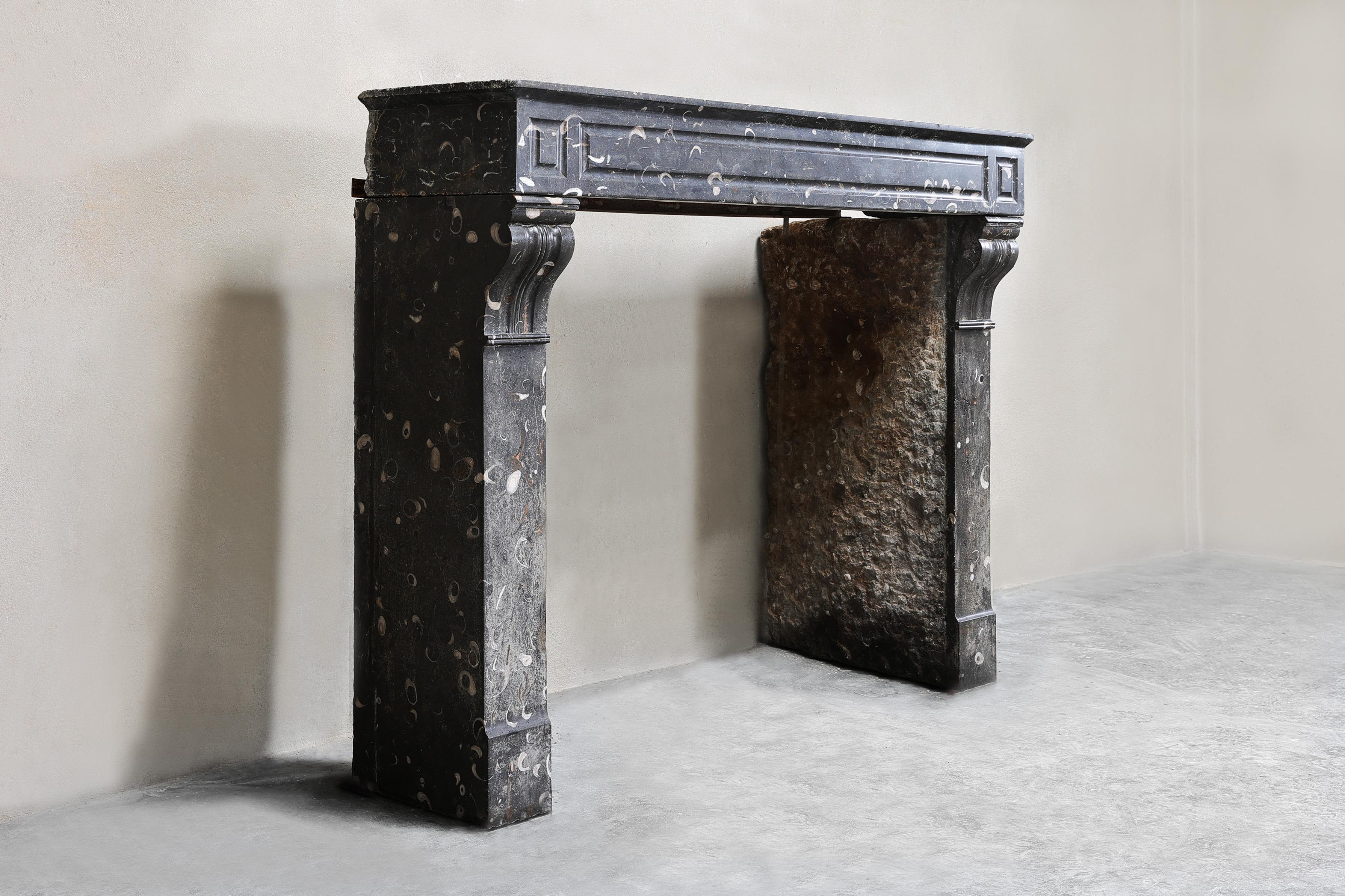 Beautiful antique mantelpiece made of beautiful black marble with light veins from the 19th century in the style of Louis XVI. This mantelpiece has a warm color nuance and beautiful straight shapes! A chic antique mantle that is compact in size and