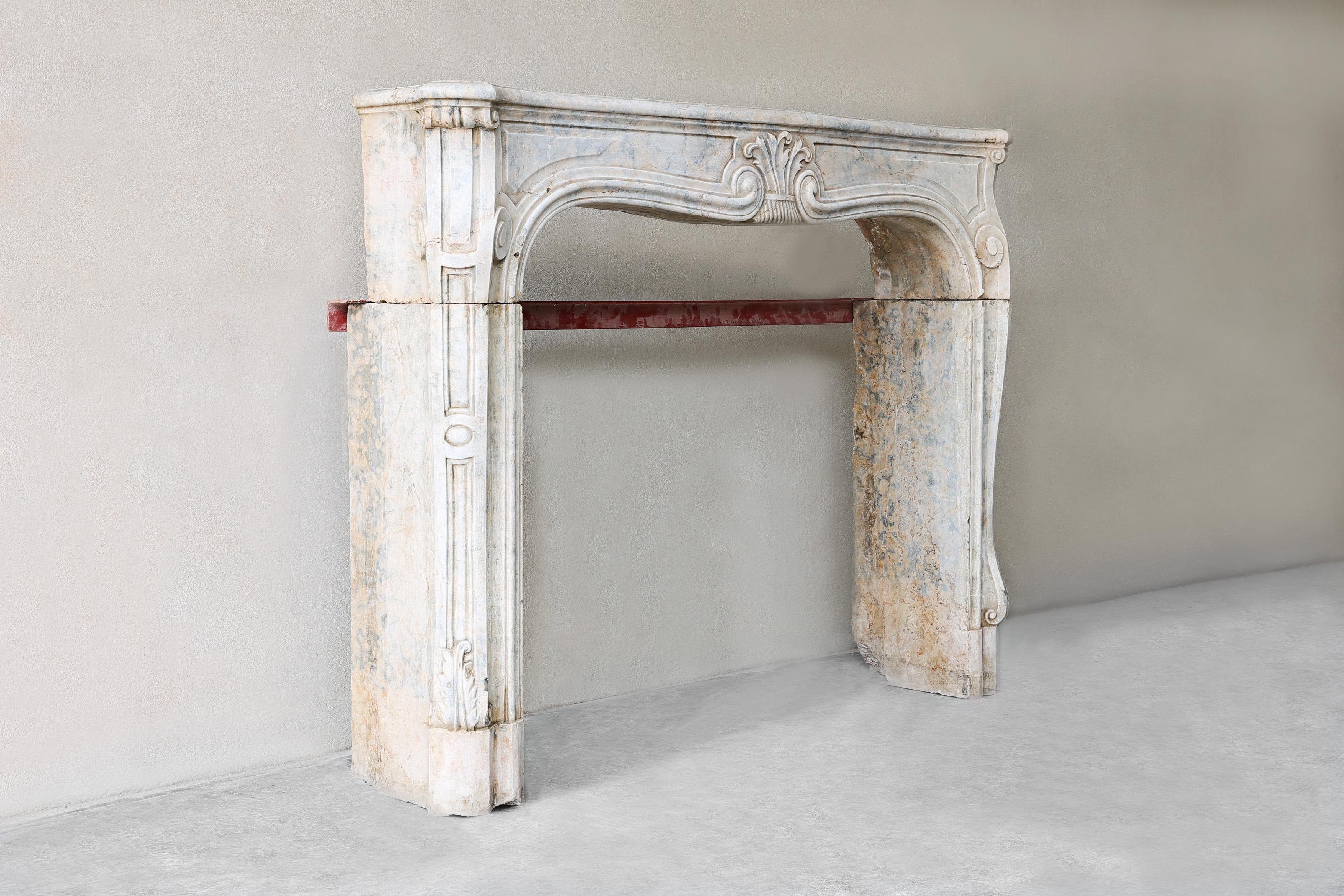 Beautiful antique mantelpiece made of Burgundian stone from the 19th century in the style of Louis XV. A very graceful mantelpiece with various ornaments and decorations. This mantelpiece has a warm appearance and compact size. A fireplace that fits