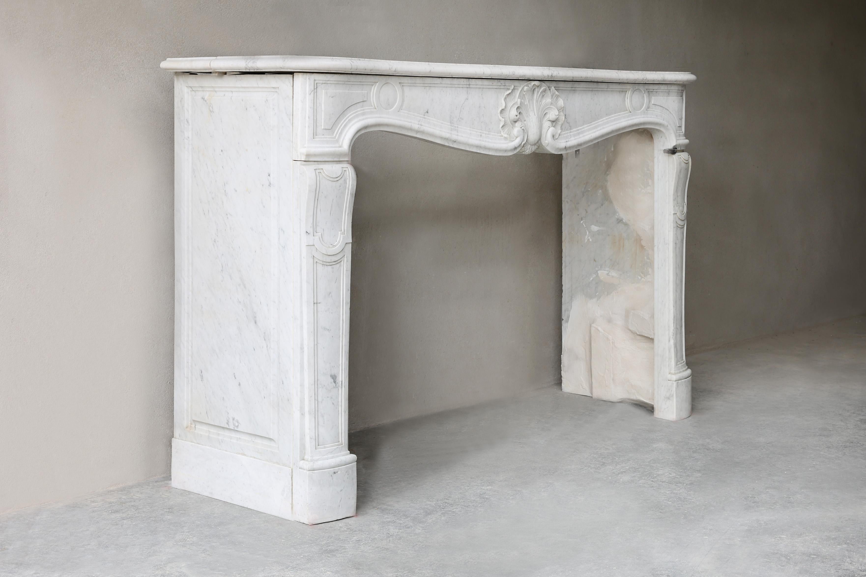 Impressionnante cheminée ancienne en marbre de 190 cm de large, de style Louis XV. Fabriqué en marbre blanc de haute qualité, avec des courbes élégantes et un ornement central détaillé. Cette large cheminée est une véritable pièce d'apparat,