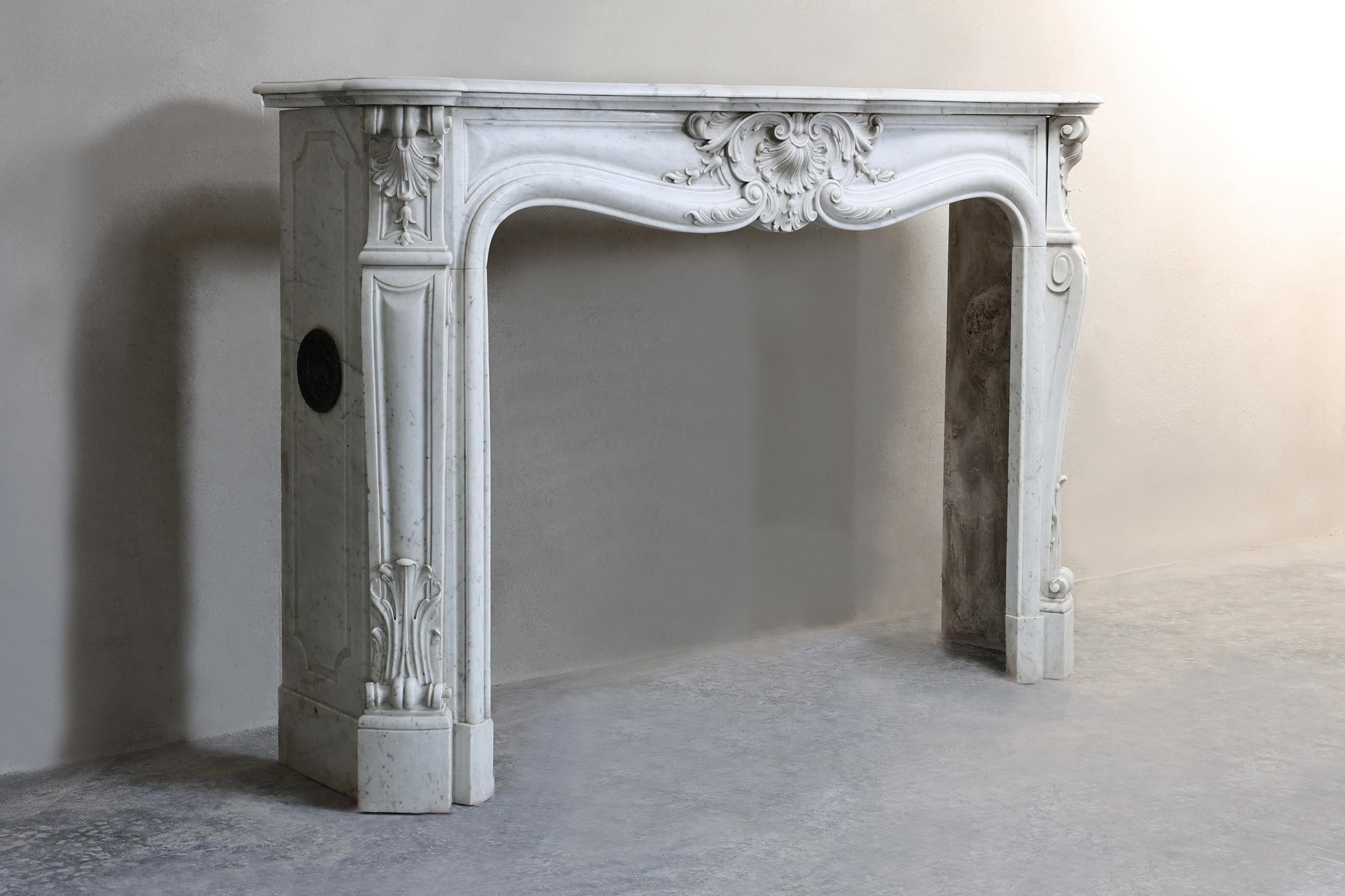 Beautiful exclusive mantelpiece made of the serene marble Carrara from Italy. This 19th century fireplace in Louis XV style is a real eye-catcher. With graceful lines and detailed finishes, this fireplace adds a luxurious and timeless charm to any