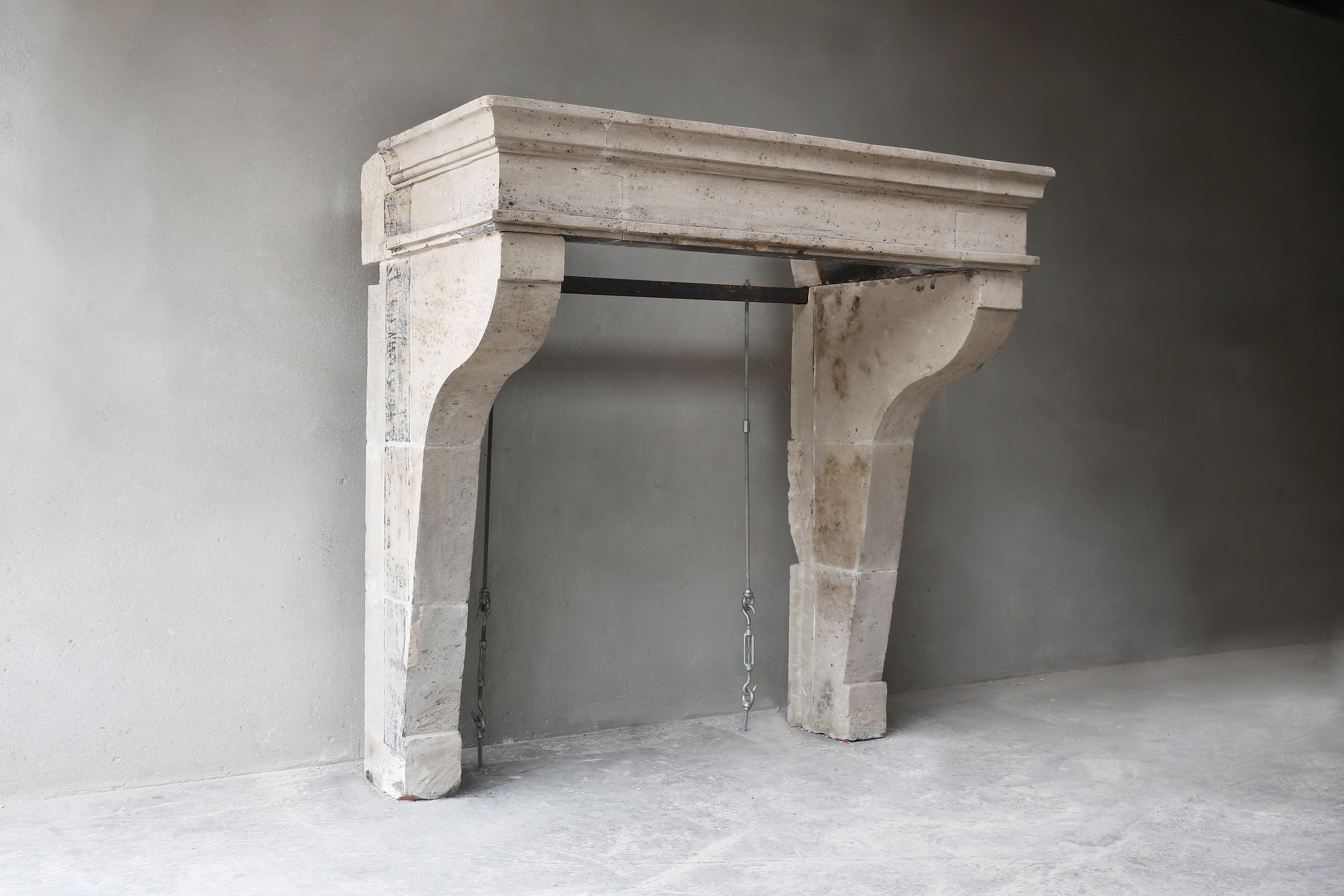 Beautiful simple antique French limestone fireplace in the style of Campagnarde from the 19th century! A fireplace with few ornaments, but beautiful lines and a size that is suitable for many interiors. The fireplace has a historic look and gives a