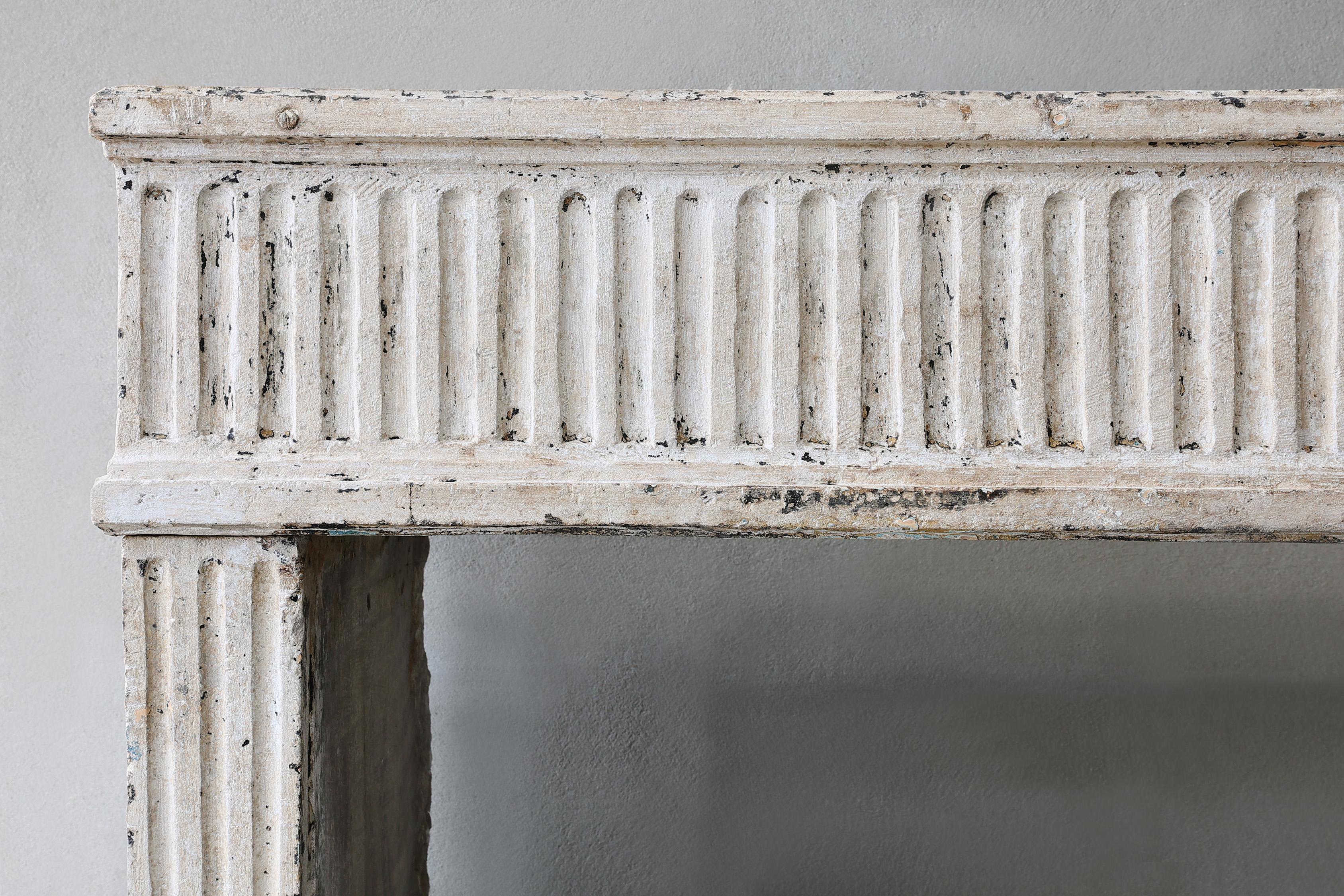 Beautiful antique French limestone fireplace in the style of Louis XVI from the 19th century! This mantelpiece has flutes on both the front part and the legs, these are the vertical lines. An attractive fireplace in the style of Louis XVI.