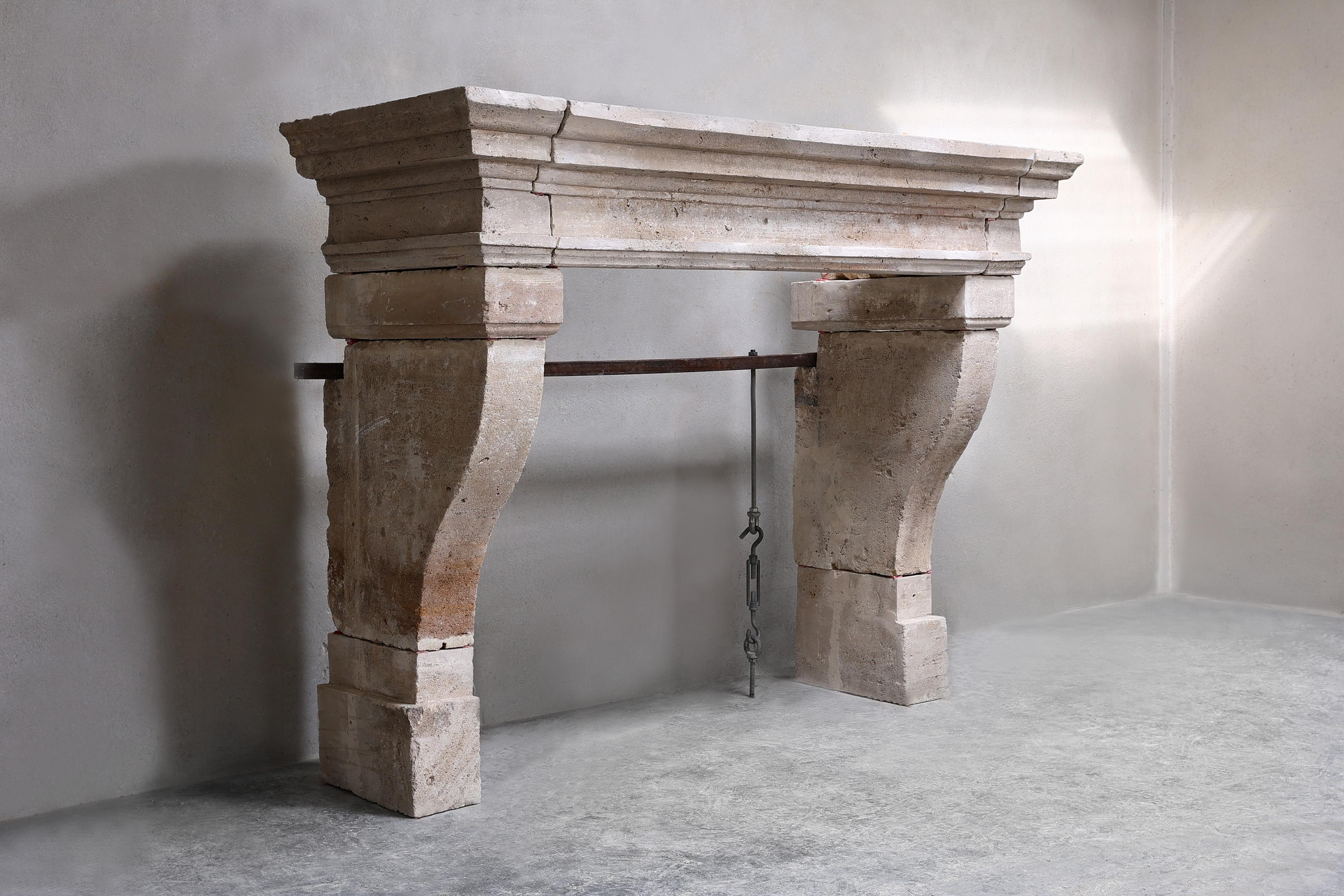 Beautiful antique French limestone fireplace with a warm color scheme and rustic look. This fireplace from the 19th century is in Campagnarde style and has beautiful lines and no ornaments, which gives this fireplace calmness.