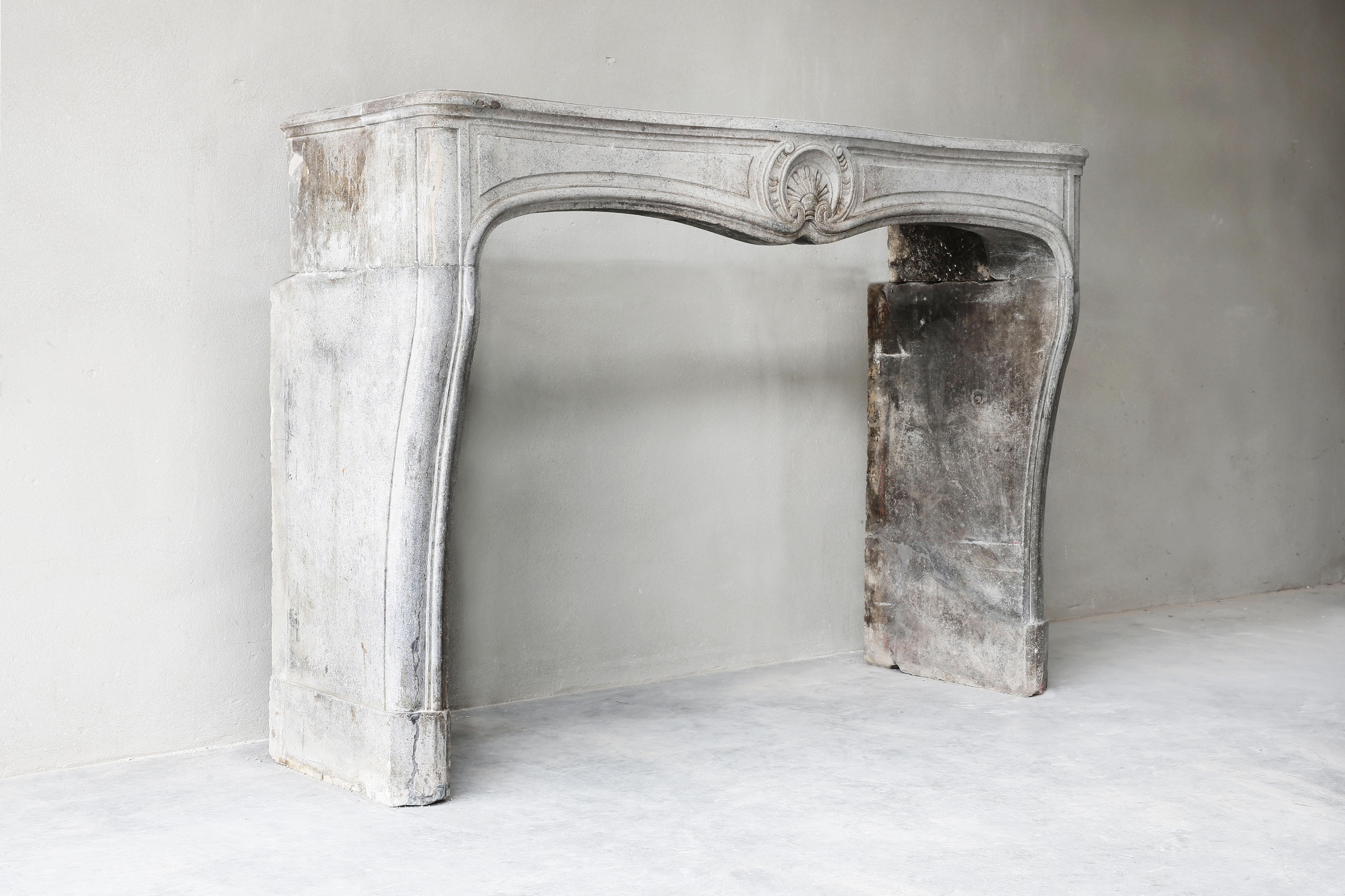 Beautiful chic antique fireplace made of gray marble. The fireplace dates from the 19th century and is completely in the style of Louis XV. The beautiful shape and scallop in the middle of the front section makes this fireplace very elegant. The