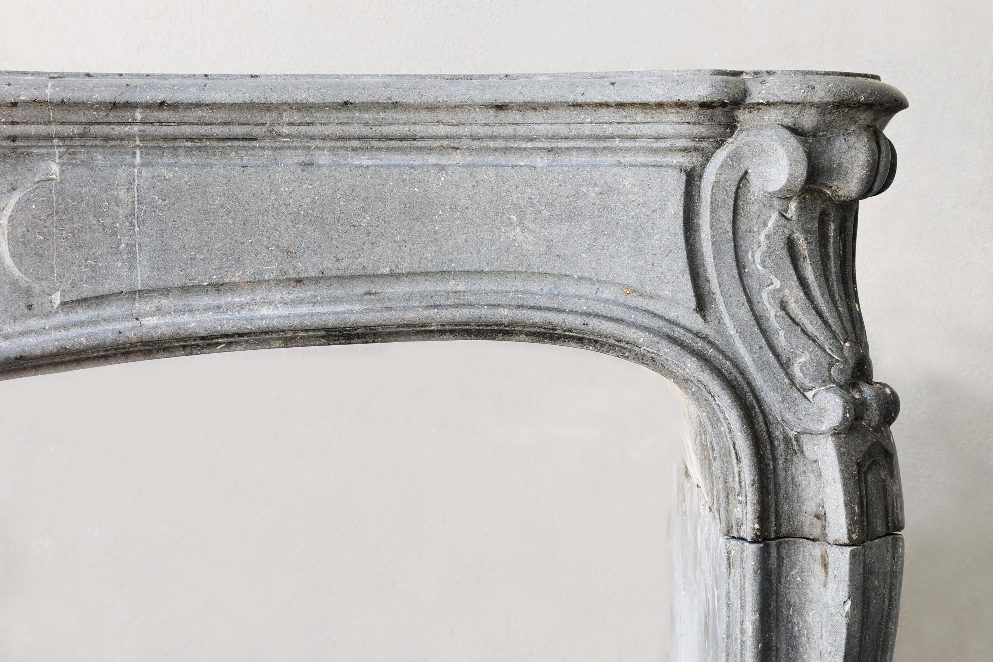 Français Cheminée ancienne en pierre marbrière grise du 19ème siècle, style Louis XV en vente
