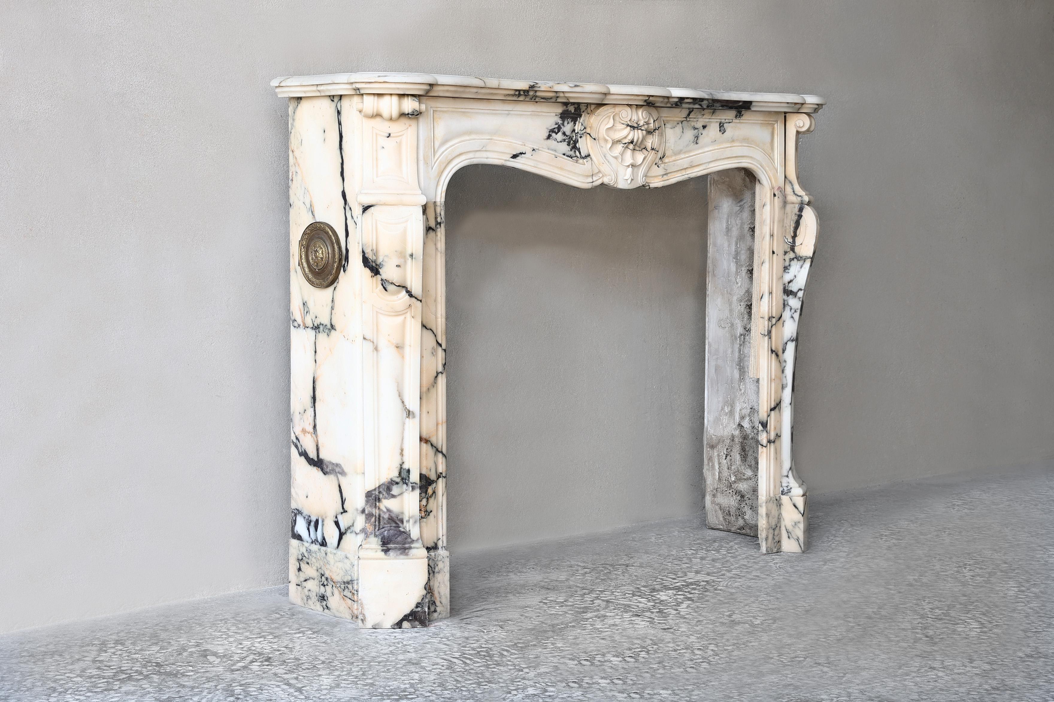 Beautiful antique fireplace of the warm marble Paonazzo from the 19th century in style of Louis XV. This fireplace has very beautiful ornaments and decorations such as a scallop in the middle and decorations on the legs. A fireplace that revives
